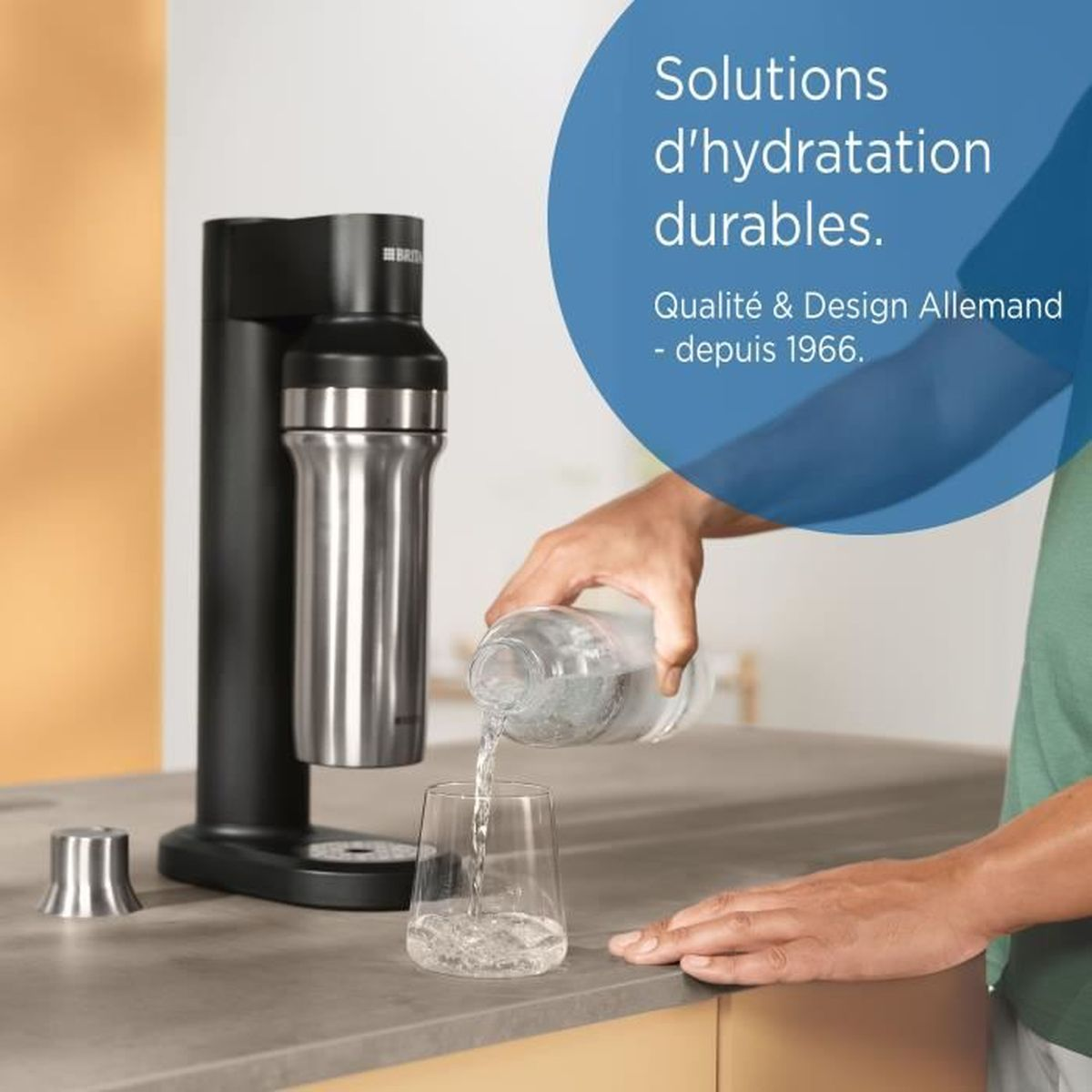 Eine Person gießt Wasser aus einer Flasche in ein Glas. Links steht ein Sodabereiter. Der Text lautet: Solutions d'hydratation durables.