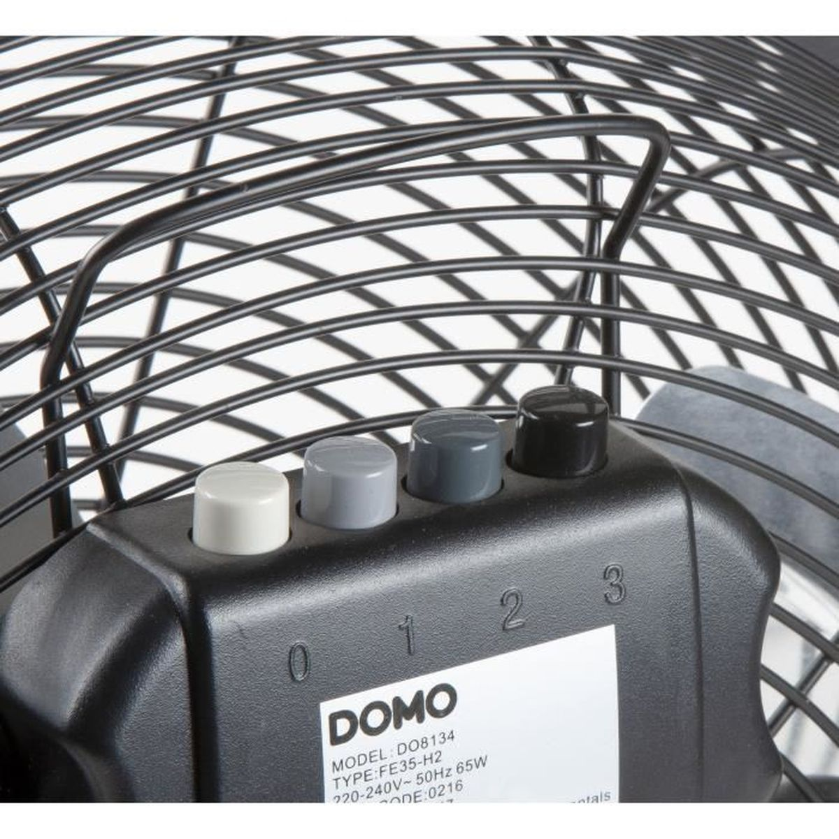 Gros plan d'un ventilateur noir avec des boutons de contrôle de vitesse. Le ventilateur a une cage de protection. Le panneau de contrôle affiche les réglages de vitesse et les informations de la marque.