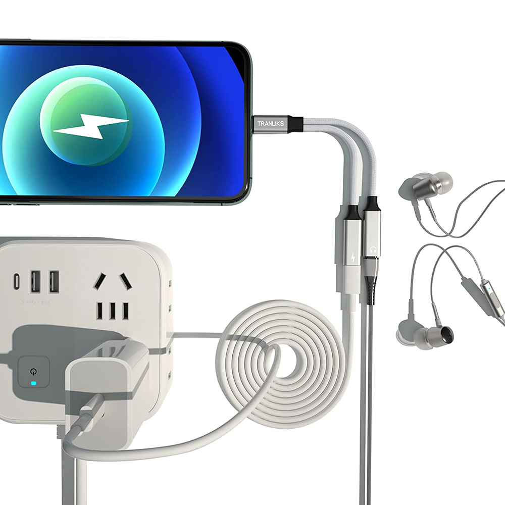 Ein Telefon lädt. Ladegerät, Kopfhörer und Steckdosenleiste sind vorhanden. Das Telefon zeigt einen Blitz. Weiße und graue Kabel.