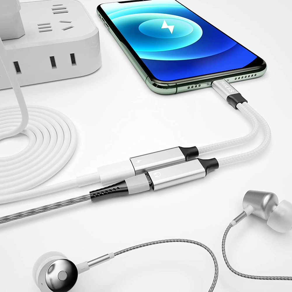 Weißes und graues Ladekabel mit einem Telefon verbunden. Kopfhörer sind rechts unten. Im Hintergrund befindet sich eine Steckdose.