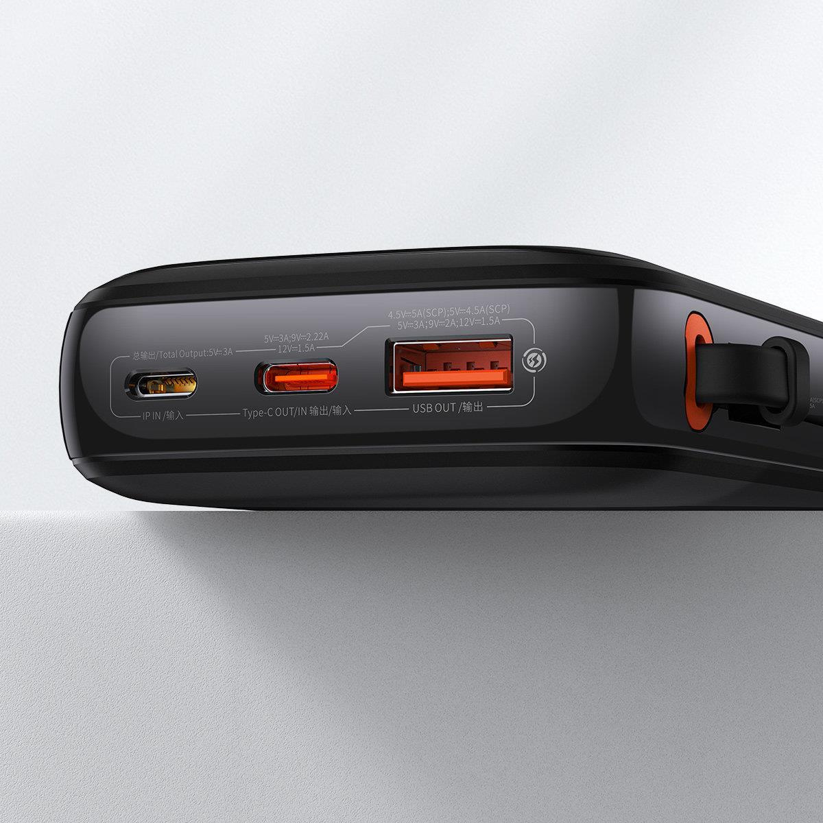 Schwarze Powerbank mit orangefarbenen Akzenten. Mit Anschlüssen IP IN, Typ-C und USB OUT. Text zeigt Spannung und Stromausgänge.