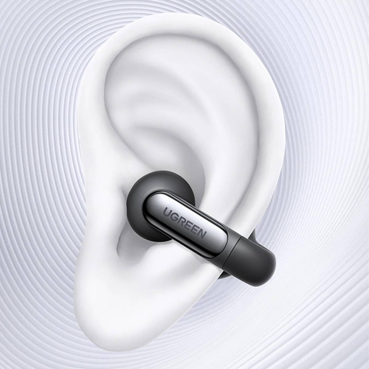 Szary pączek UGREEN jest włożony w białe ucho. Tło ma biały, falisty wzór.