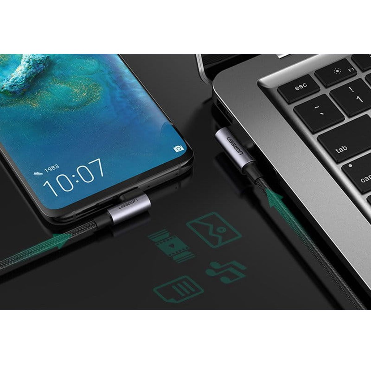 Telefon i laptop są połączone kablem USB-C. Telefon pokazuje godzinę. Na powierzchni znajdują się ikony.