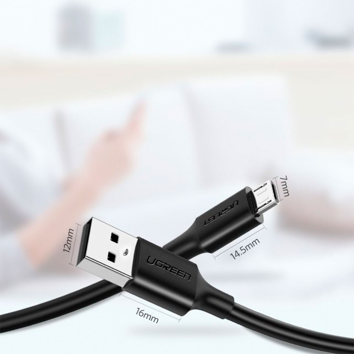 Czarny kabel USB UGREEN z złączem micro USB. Wymiary są wskazane. Rozmyta dłoń w tle.
