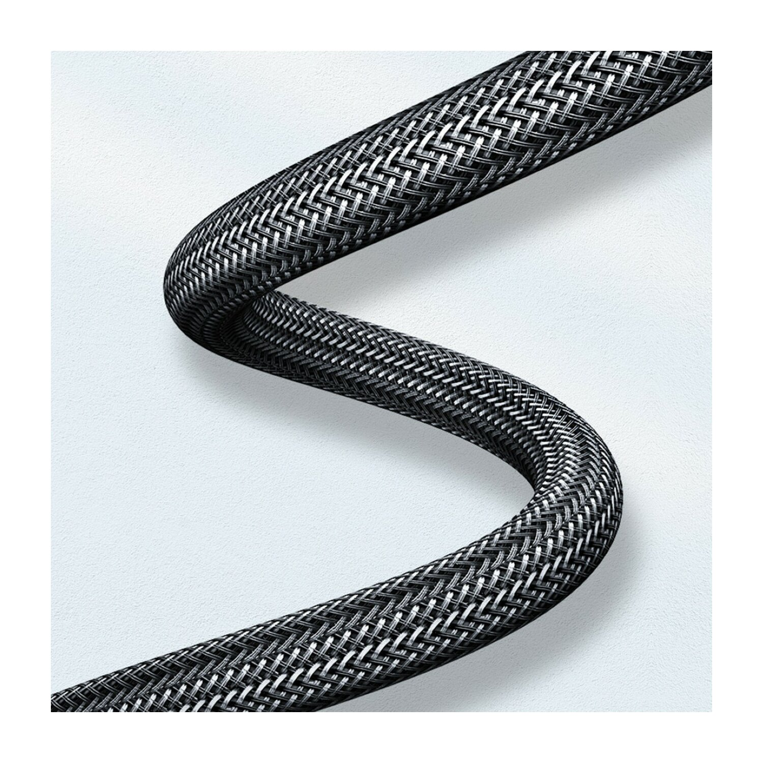 Czarno-srebrny pleciony kabel zakręca na białym, teksturowanym tle.