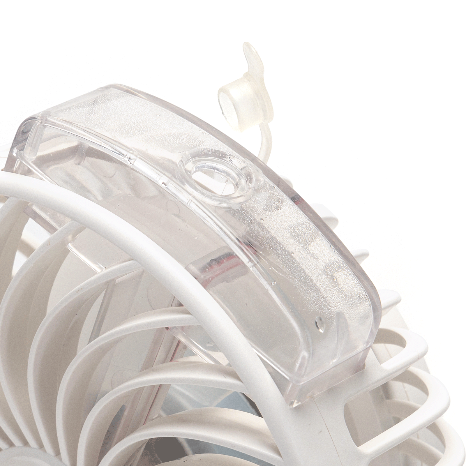 Primer plano de un ventilador blanco y transparente. Una cubierta de plástico transparente en la parte superior.