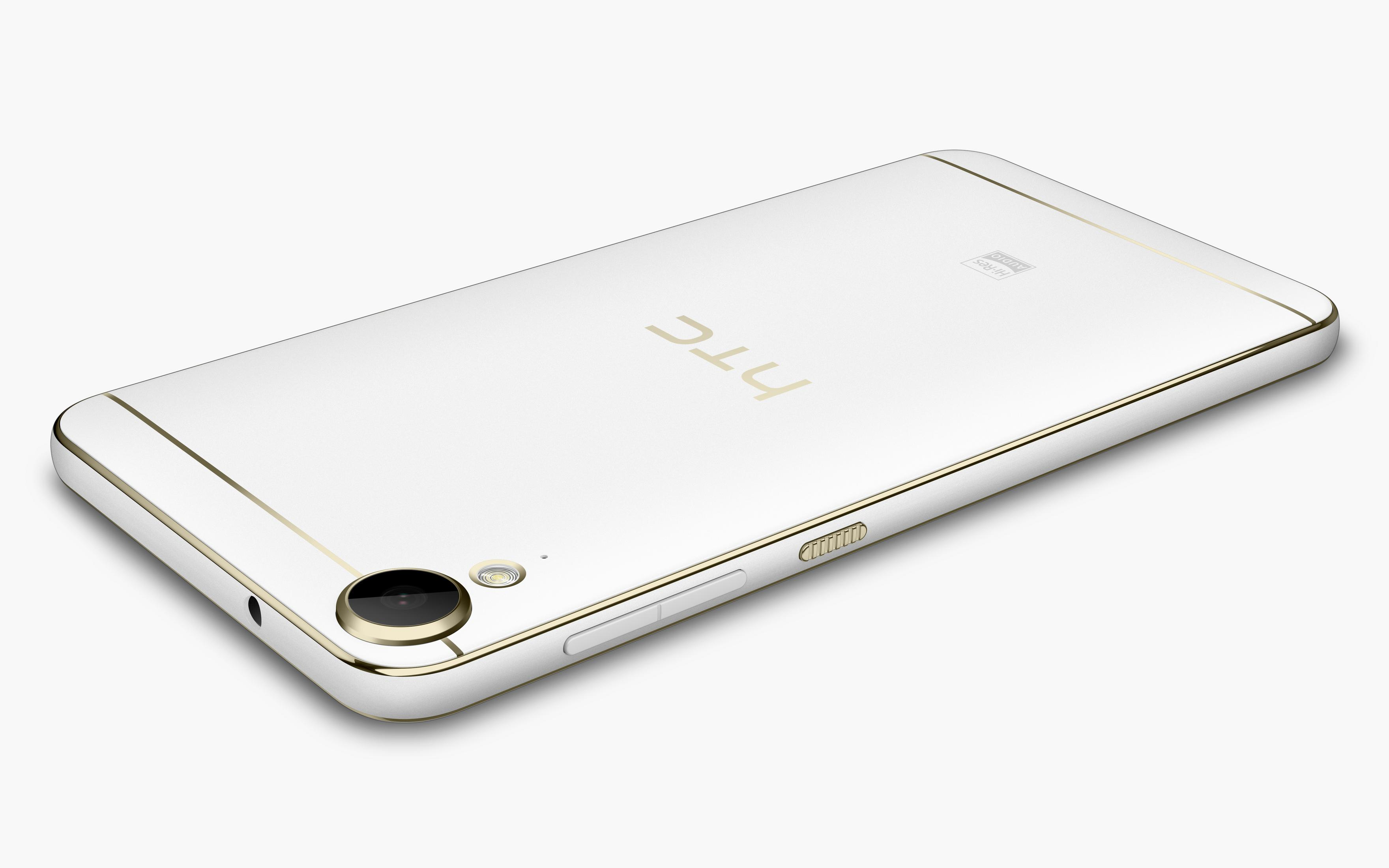 Weißes HTC-Telefon mit goldfarbenem Rand. Mit Kamera, Tasten und HTC-Logo. Das Telefon befindet sich auf weißem Hintergrund.
