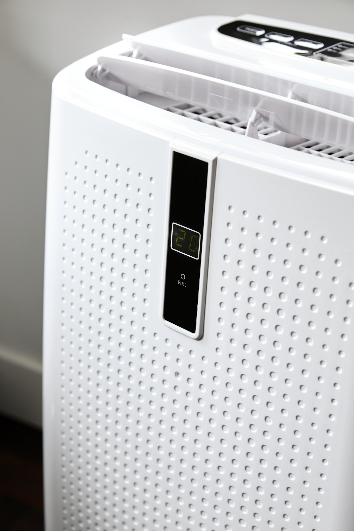 Een witte luchtreiniger met digitaal display '20'. Het heeft een geperforeerde voorkant en ventilatie bovenaan.