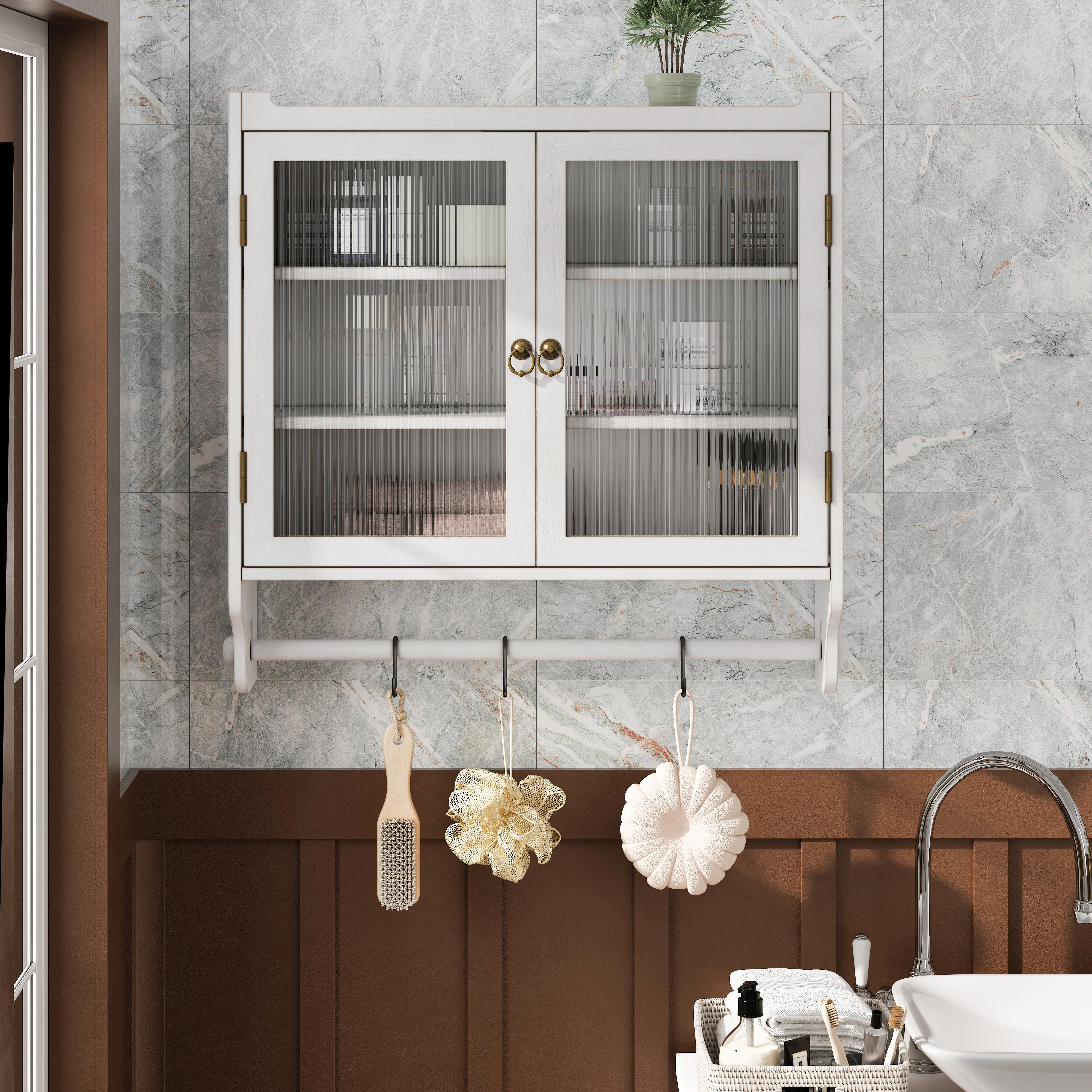 Ein weißer Schrank mit Glastüren, ein Waschbecken und verschiedene Toilettenartikel. Die Wand hat marmorähnliche Fliesen.