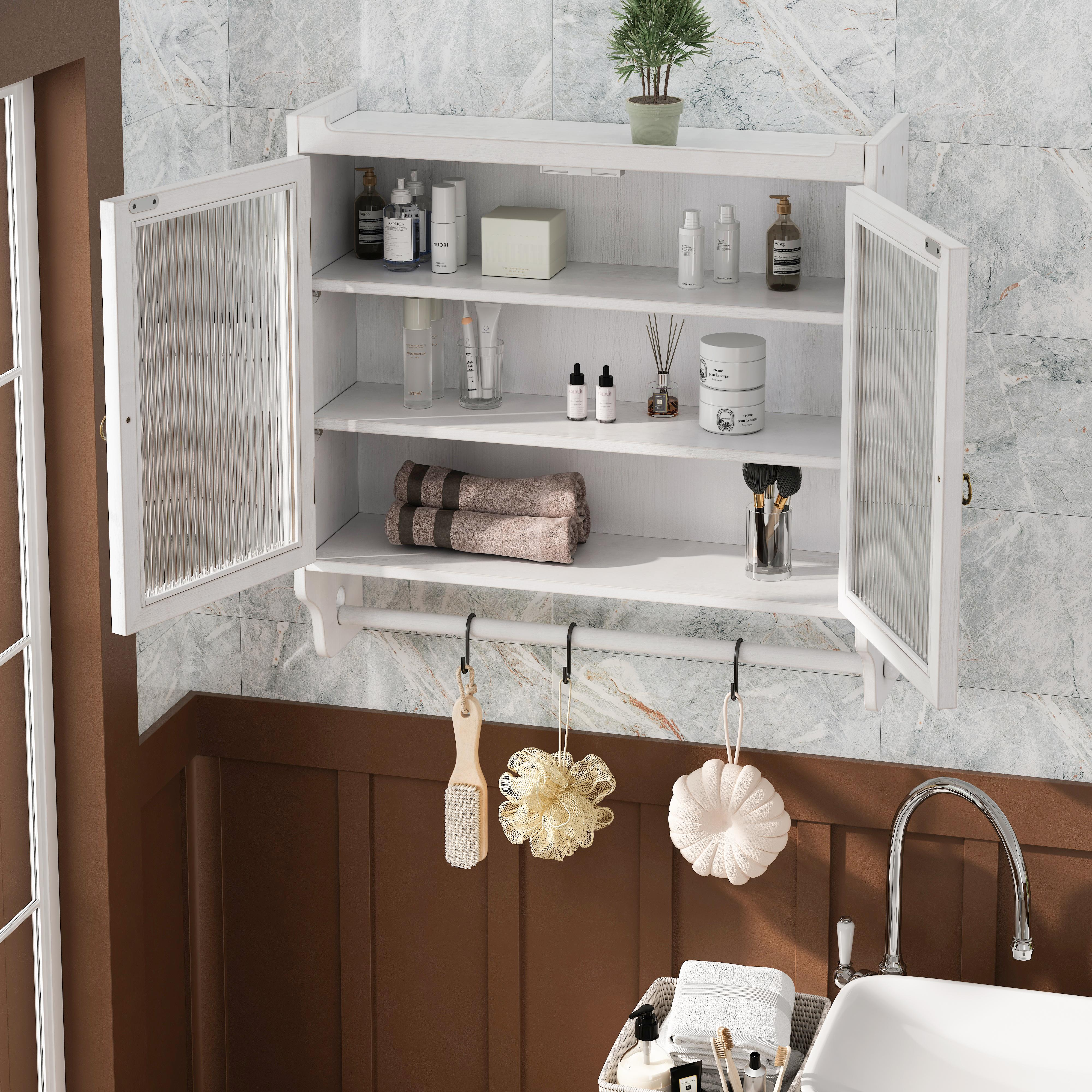 Weißer Schrank mit offenen Glastüren, der Toilettenartikel enthält. Haken mit Badartikeln hängen darunter. Braune Wand und Marmorfliesen.