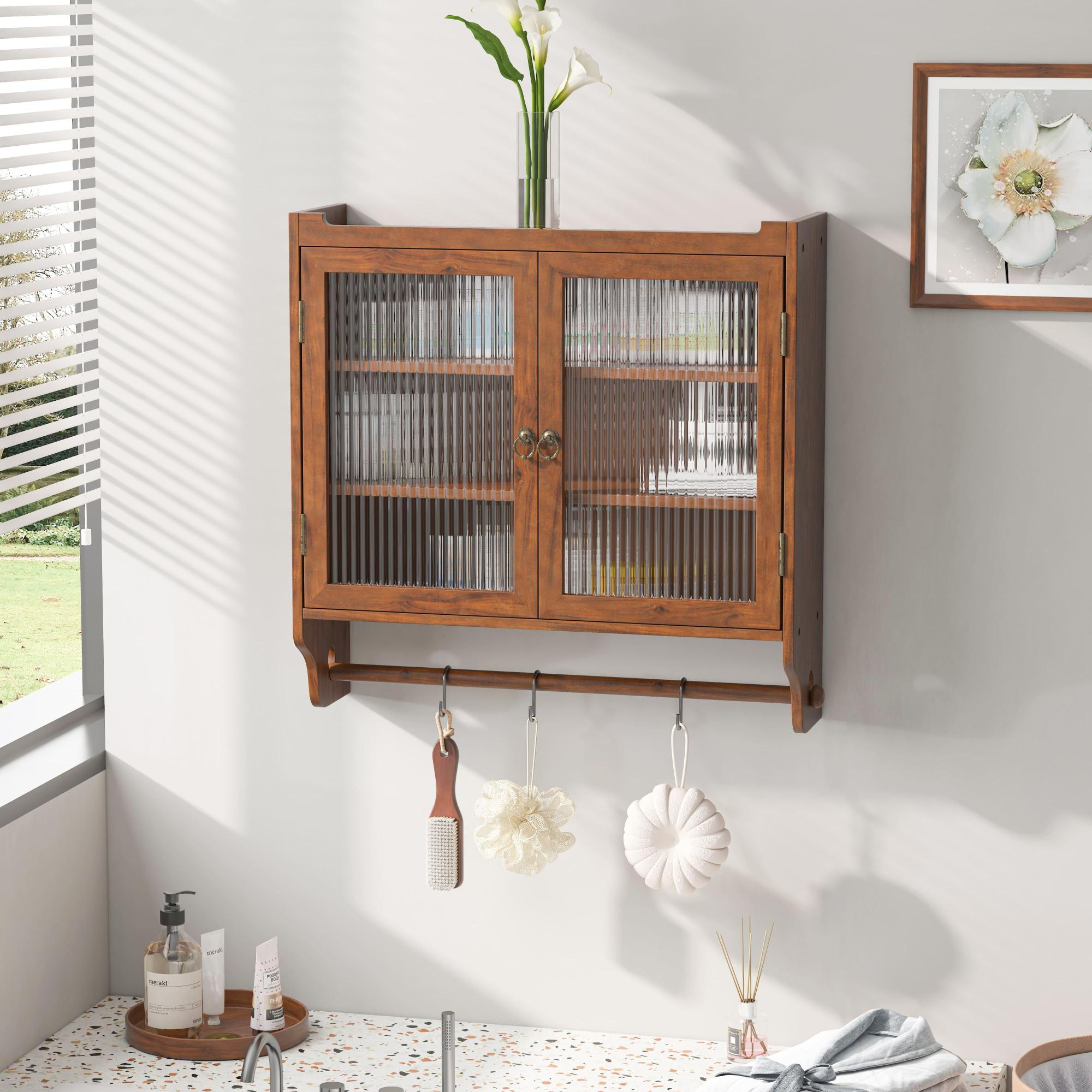 Ein Holzschrank mit Glastüren, Blumen in einer Vase und hängende Gegenstände an einem Handtuchhalter. Rechts ist ein gerahmtes Blumenkunstwerk.