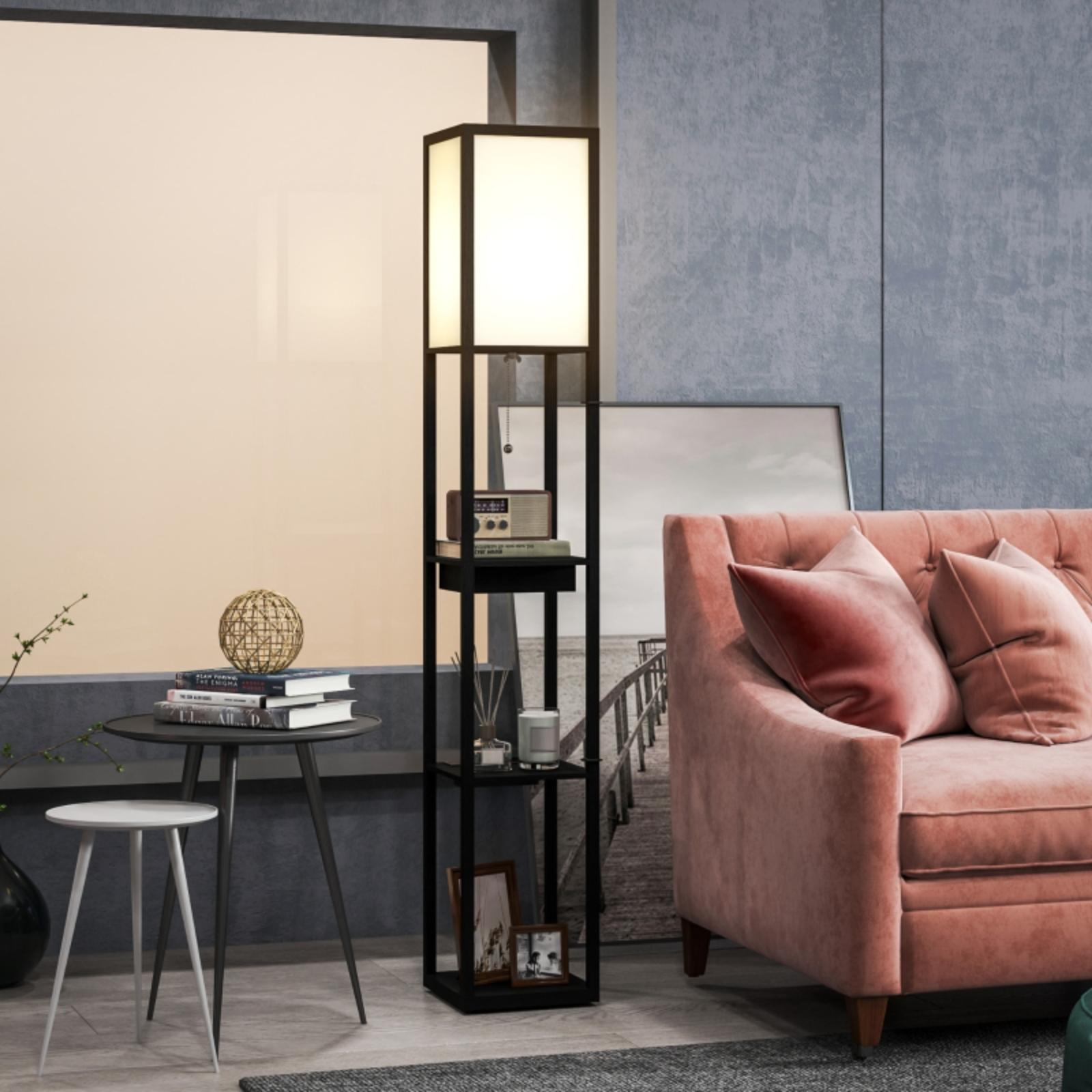 Ein Wohnzimmer mit Stehlampe, Sofa und Tischen. Im Hintergrund ein Fenster. Der Raum ist in Grau- und Rosatönen gehalten.
