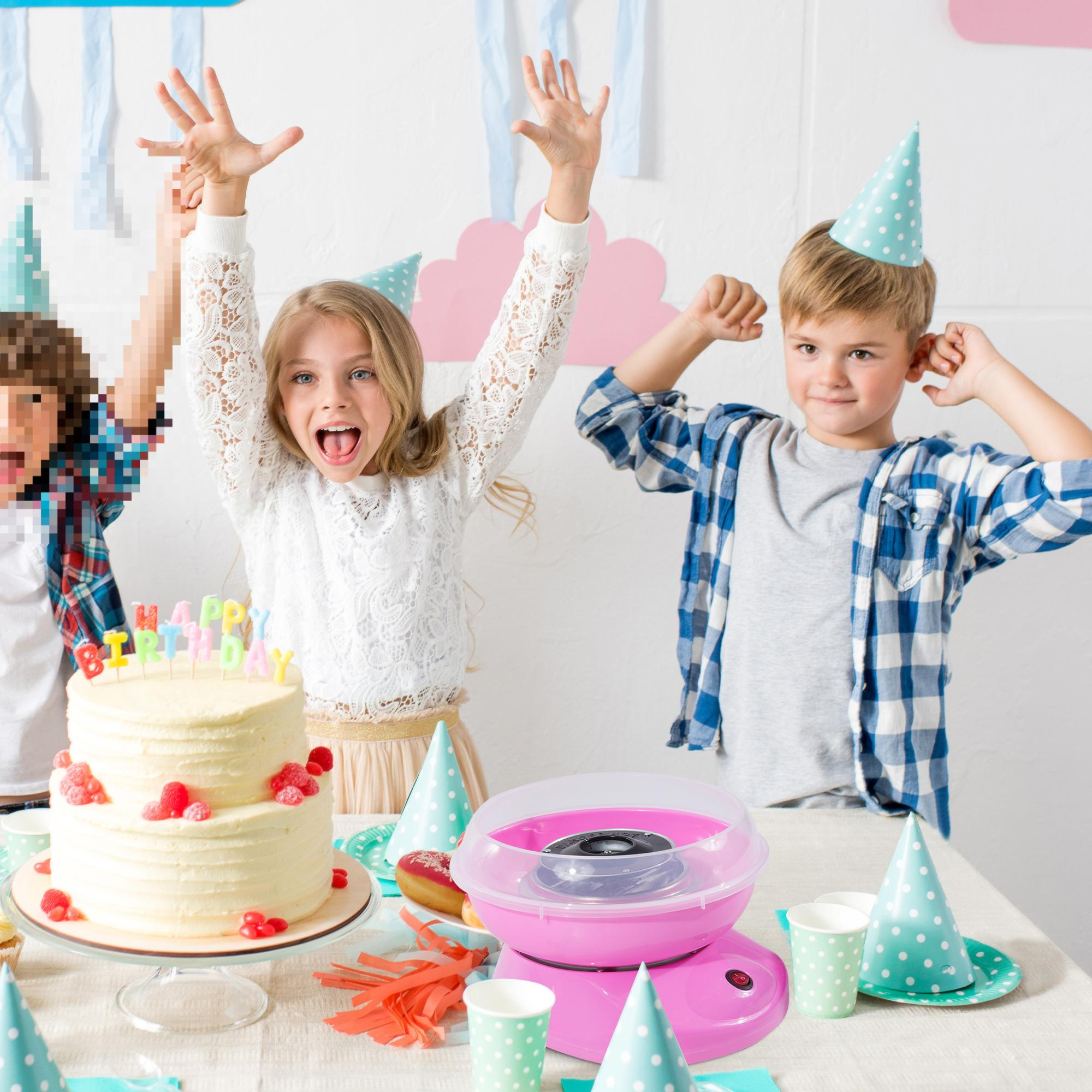 Kinder feiern Geburtstag, Kuchen und Zuckerwatte. Zwei Kinder heben die Arme, eines mit offenem Mund.