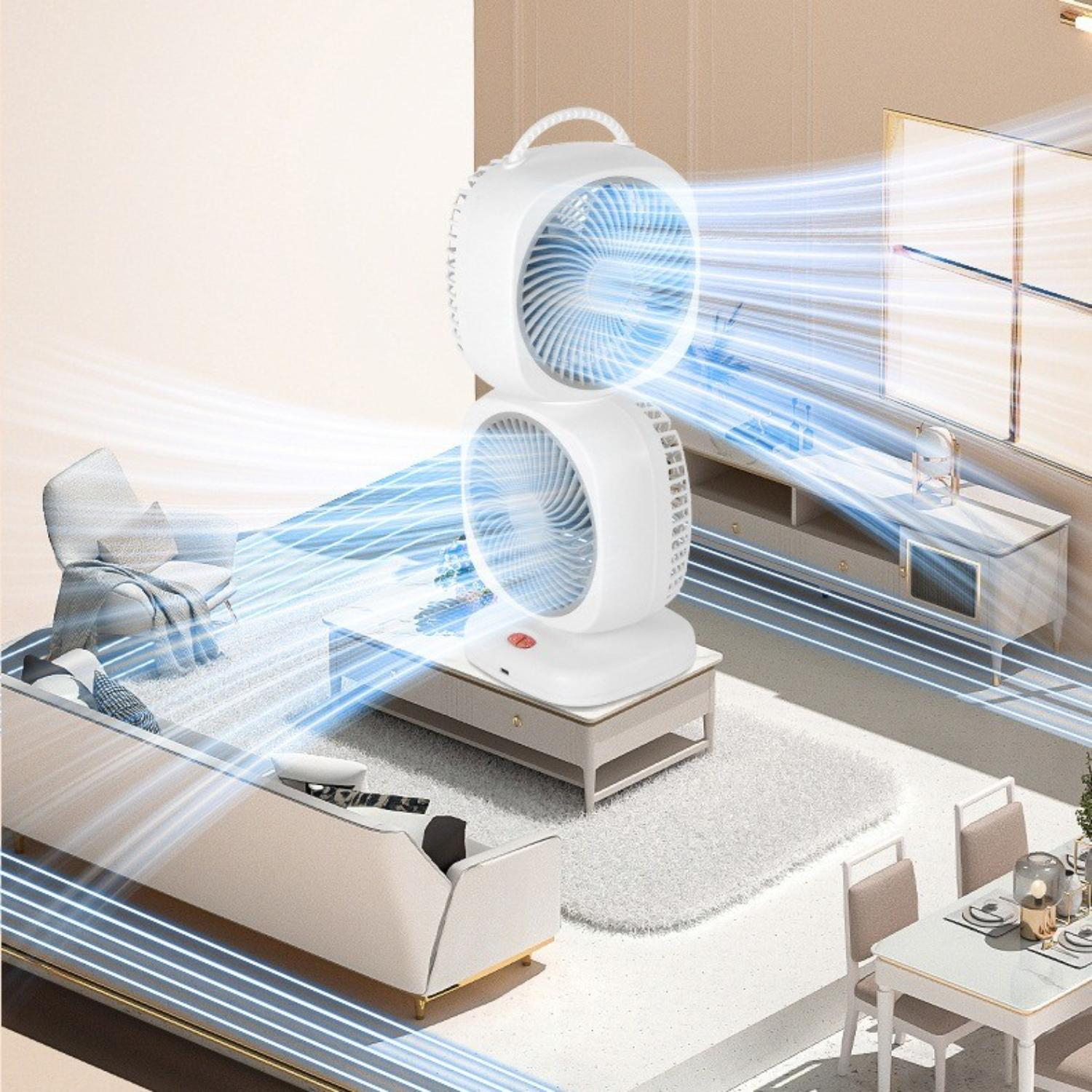 Ein weißer Doppelflügelventilator auf einem Tisch, der Luft durch ein Wohnzimmer mit Sofa, Teppich und Esstisch bläst.