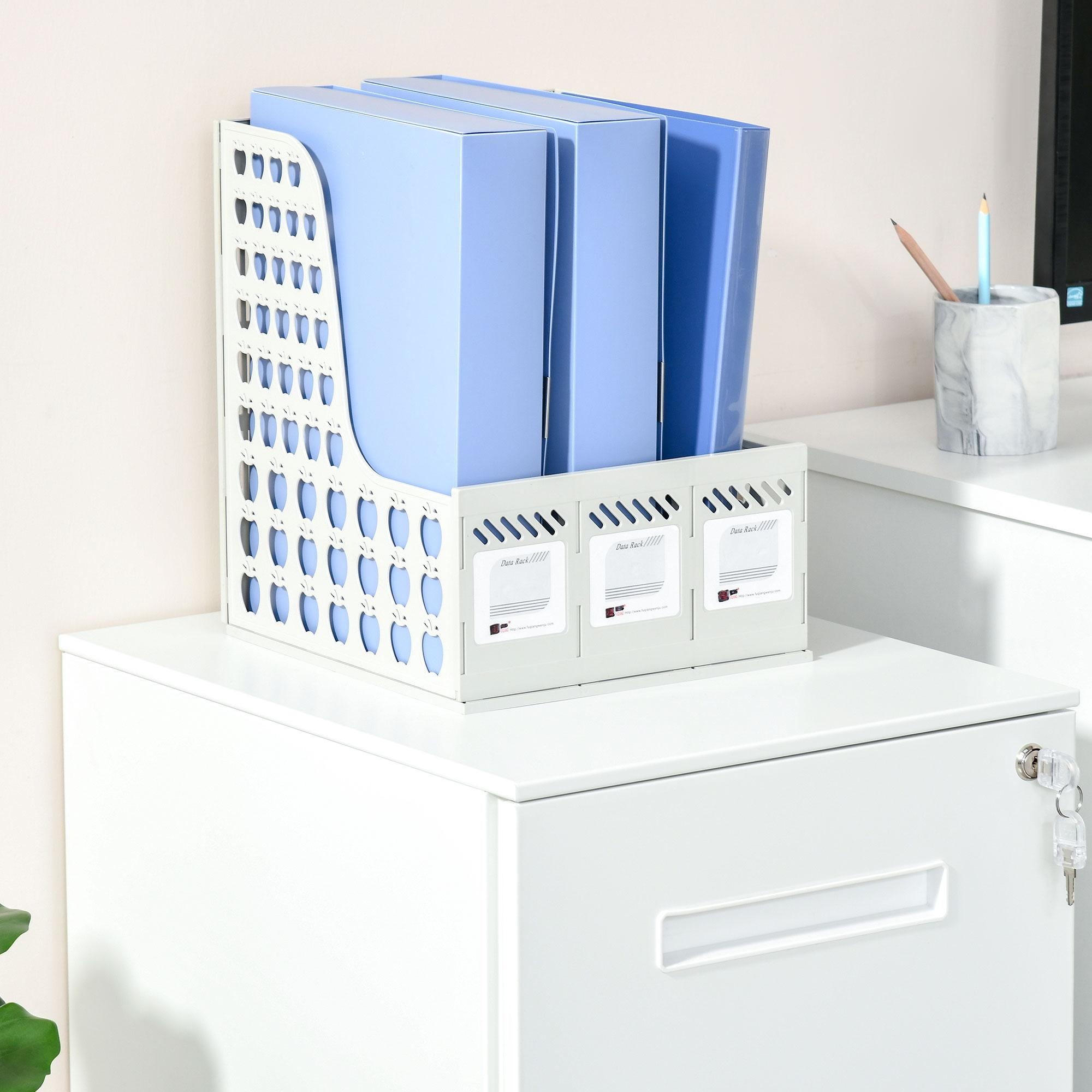 Ein weißes Aktenregal mit blauen Akten steht auf einem weißen Schrank. Bleistifte in einem Marmorbecher auf weißer Oberfläche.