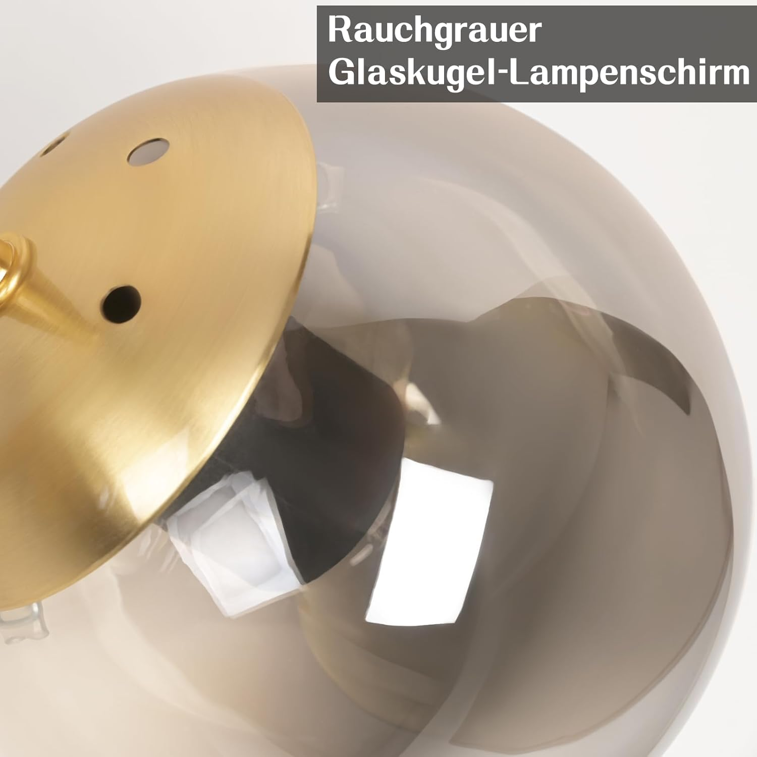 Zbliżenie lampy. Ma mosiężny wierzch z otworami i szarą kulę ze szkła dymnego. Tło jest białe.