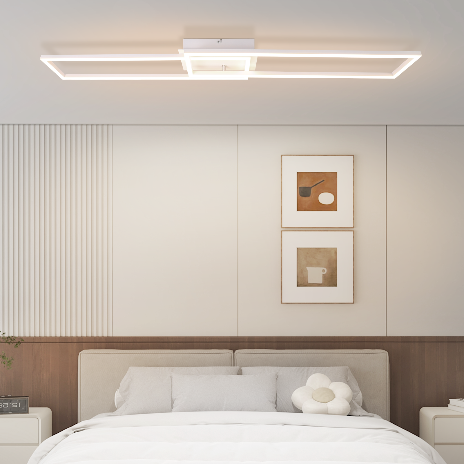 Un dormitorio con cama, mesitas de noche, obras de arte y una moderna lámpara de techo. Las paredes son color crema.