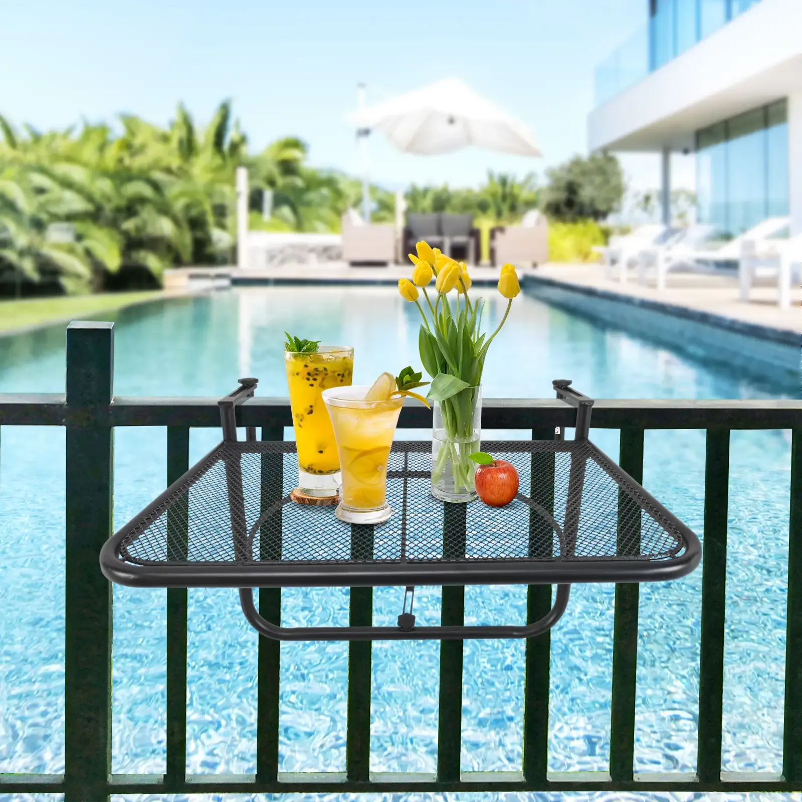 Tisch mit Getränken und Blumen am Pool. Gelbe Cocktails, Tulpen und ein Apfel sind auf dem Tisch.