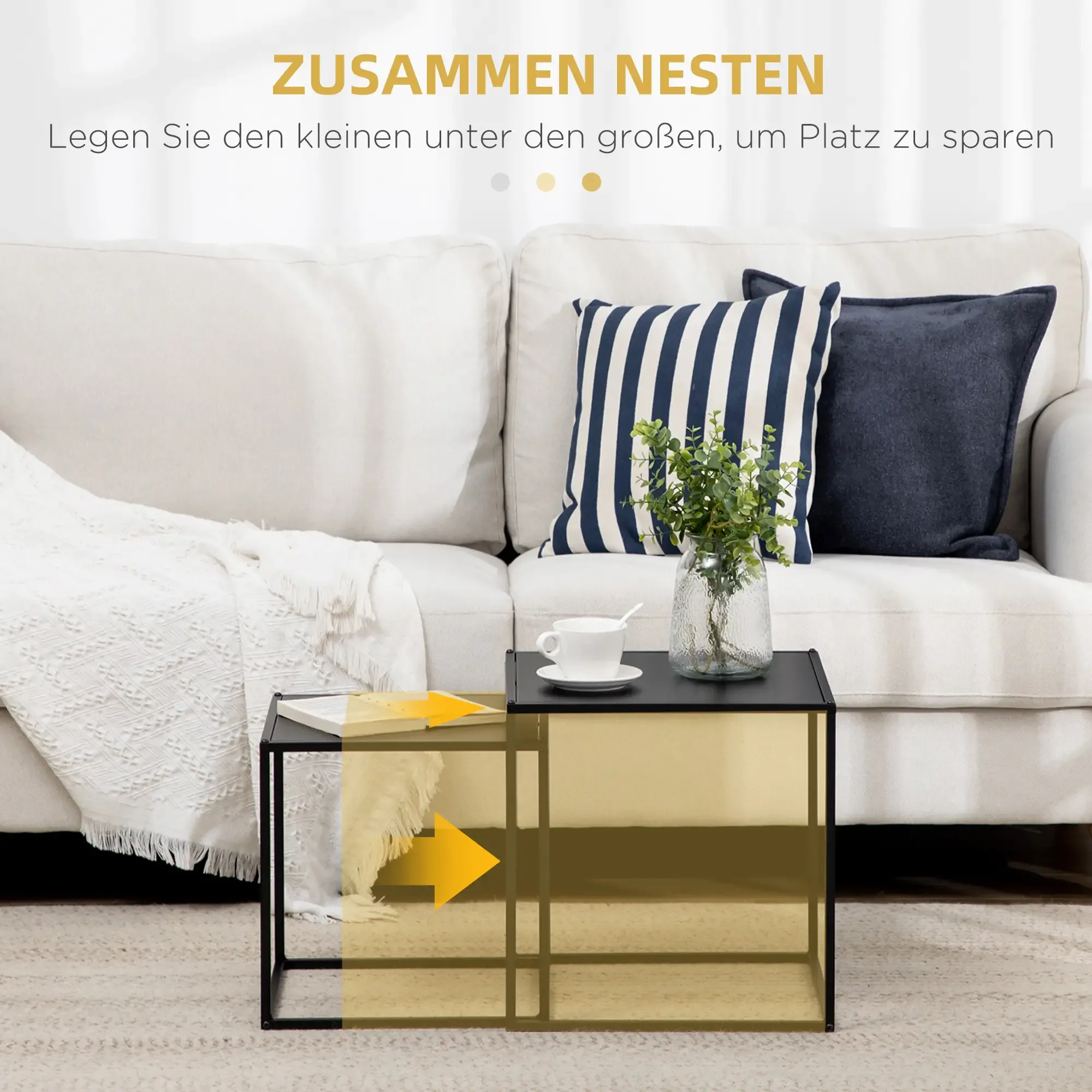Ein weißes Sofa mit Kissen und einem schwarzen Beistelltisch. Es gibt eine Glasvase mit Pflanzen und eine Tasse Kaffee.