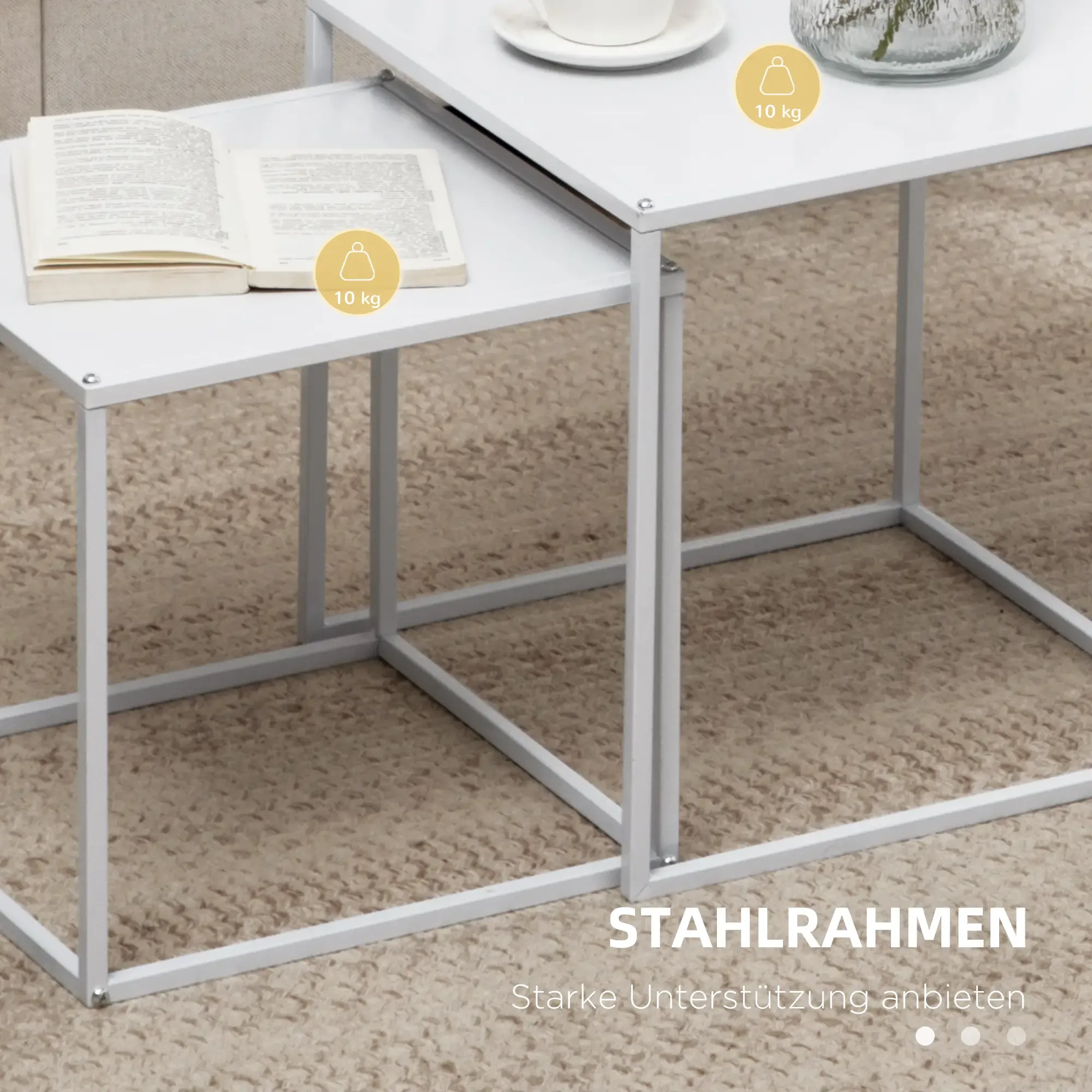 Zwei weiße, quadratische Tische, einer kleiner unter dem anderen, mit Buch, Tasse und Vase. Stahlrahmen Design.