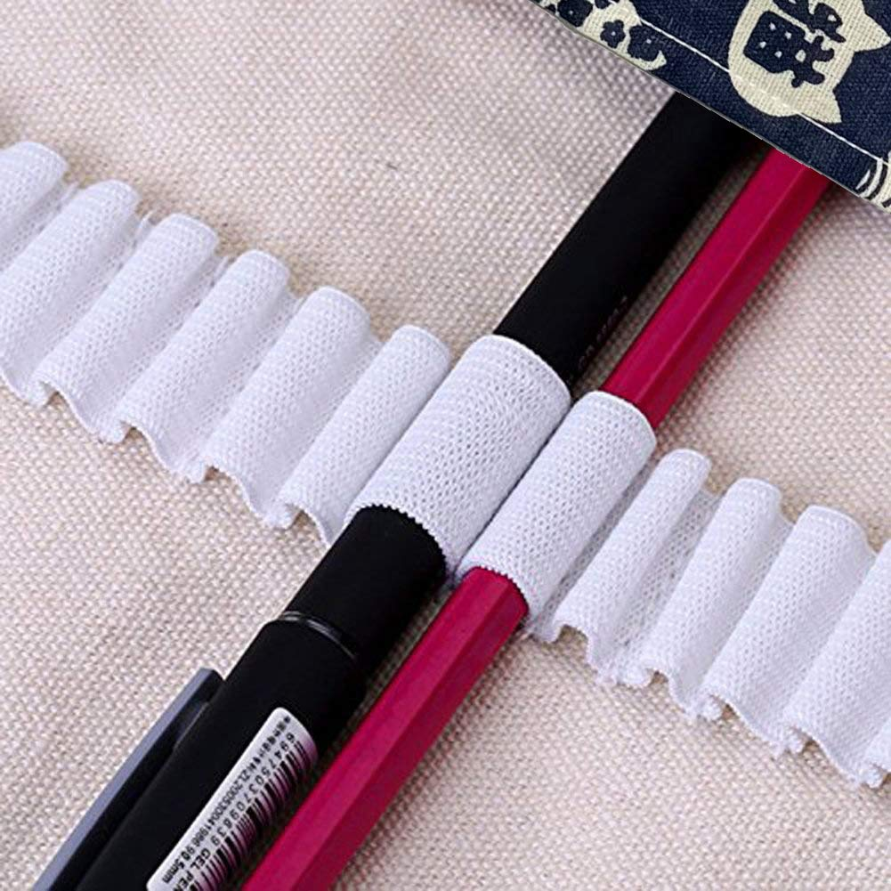 Ein schwarzer Stift und ein roter Bleistift liegen nebeneinander. Weißer Stoff umhüllt die Stifte. Im Hintergrund ist ein gemusterter Stoff zu sehen.