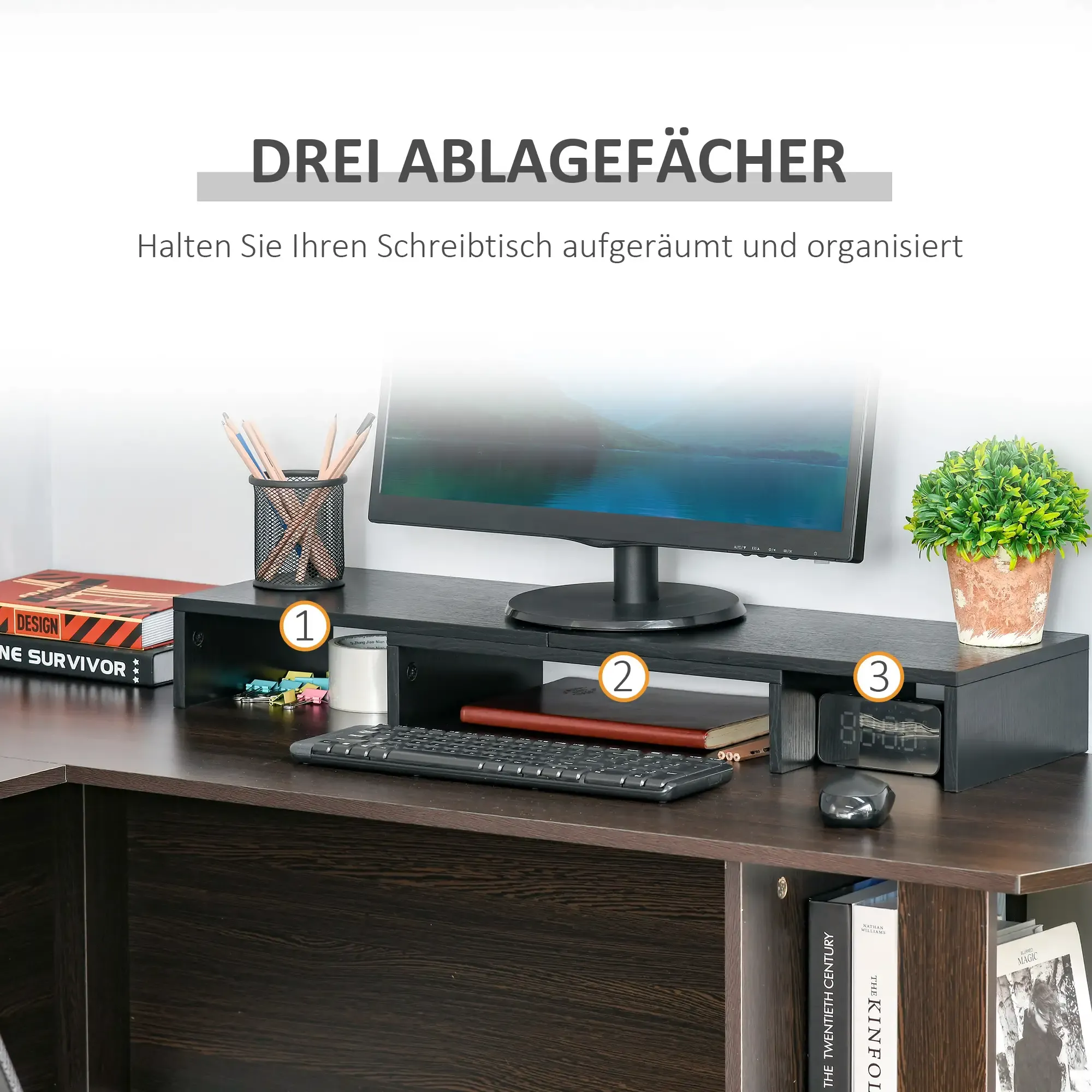 Ein Schreibtisch mit Monitor, drei Staufächern und Zubehör. Enthält Tastatur, Uhr und Topfpflanze.
