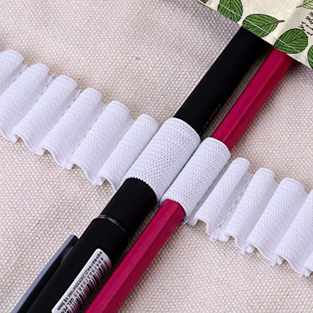 Ein schwarzer Stift und ein rosa Bleistift liegen nebeneinander. Beide sind teilweise mit weißem Netz bedeckt. Weißer Stoff ist im Vordergrund.