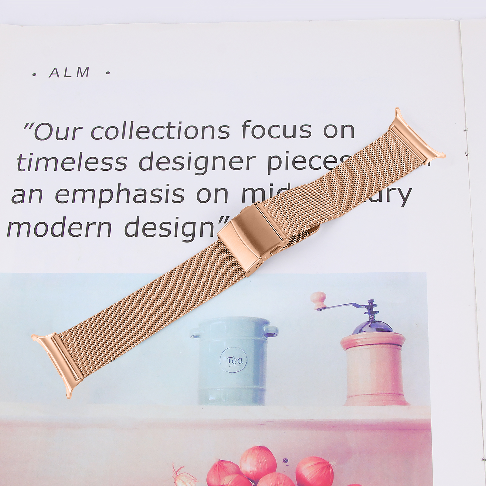 Roségoldenes Uhrenarmband auf einer weißen Seite mit Text, einem Teebehälter und einer Mühle im Hintergrund.