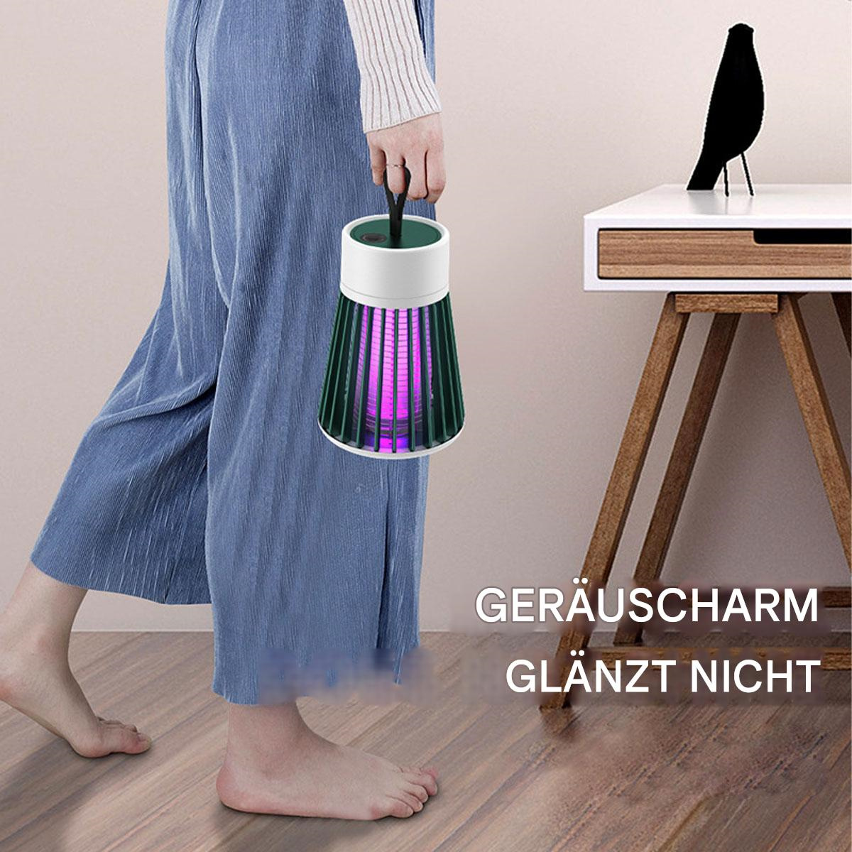 Eine Person hält einen Insektenvernichter. Der Zapper ist grün und weiß und gibt violettes Licht ab. Eine schwarze Vogelstatue steht auf einem Beistelltisch.