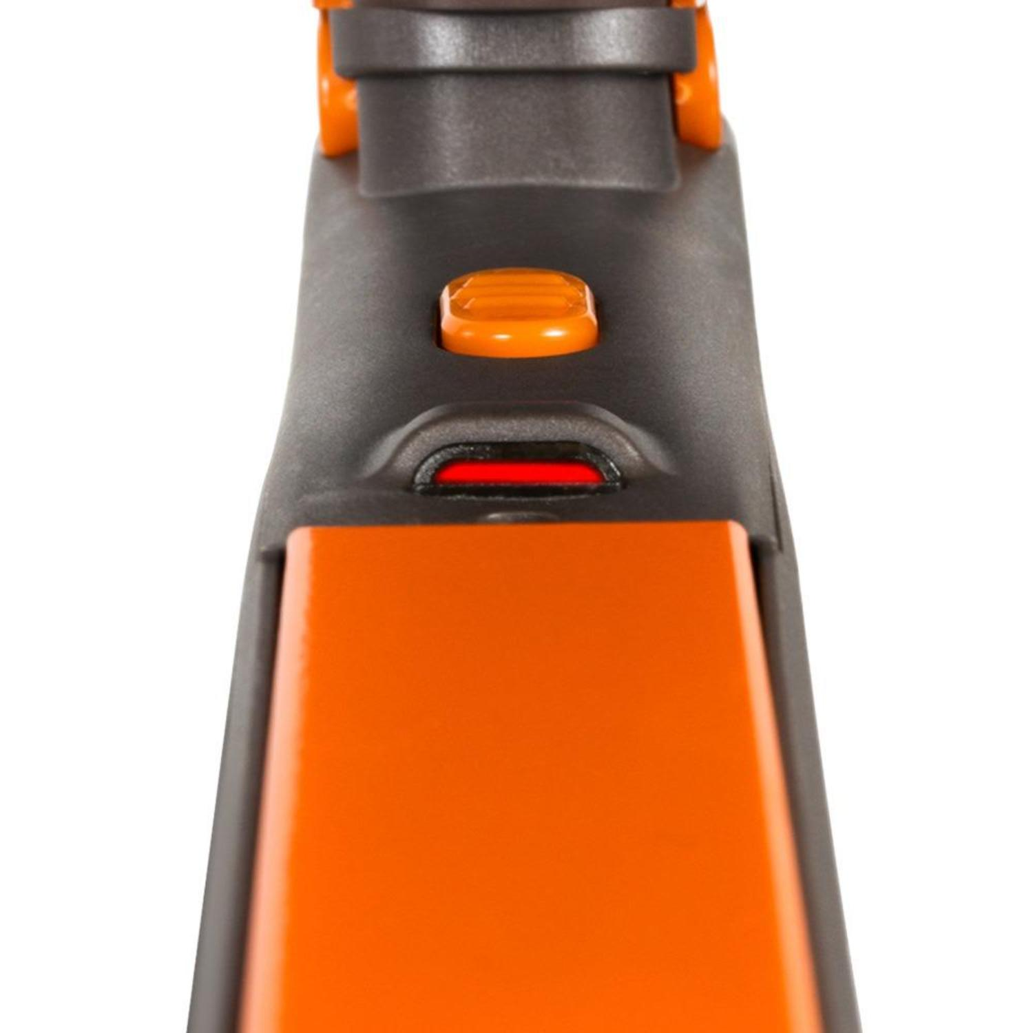 Nahaufnahme eines orangefarbenen und schwarzen Geräts. Ein rotes Licht ist sichtbar. Oben befindet sich eine orangefarbene Taste.