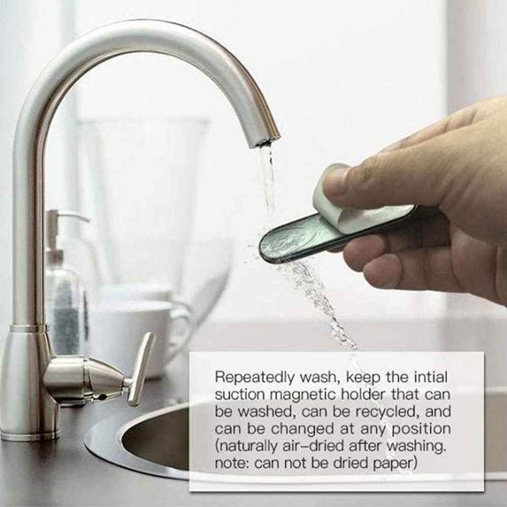 Eine Hand wäscht einen kleinen, schwarzen Magnethalter unter einem Wasserhahn. Wasser strömt aus dem Wasserhahn.
