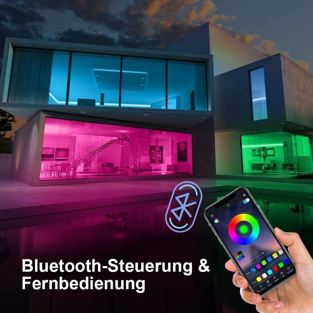 Modernes Haus mit farbwechselnden Lichtern, gesteuert von einem Telefon. Hand, die ein Telefon mit einem Farbrad hält.
