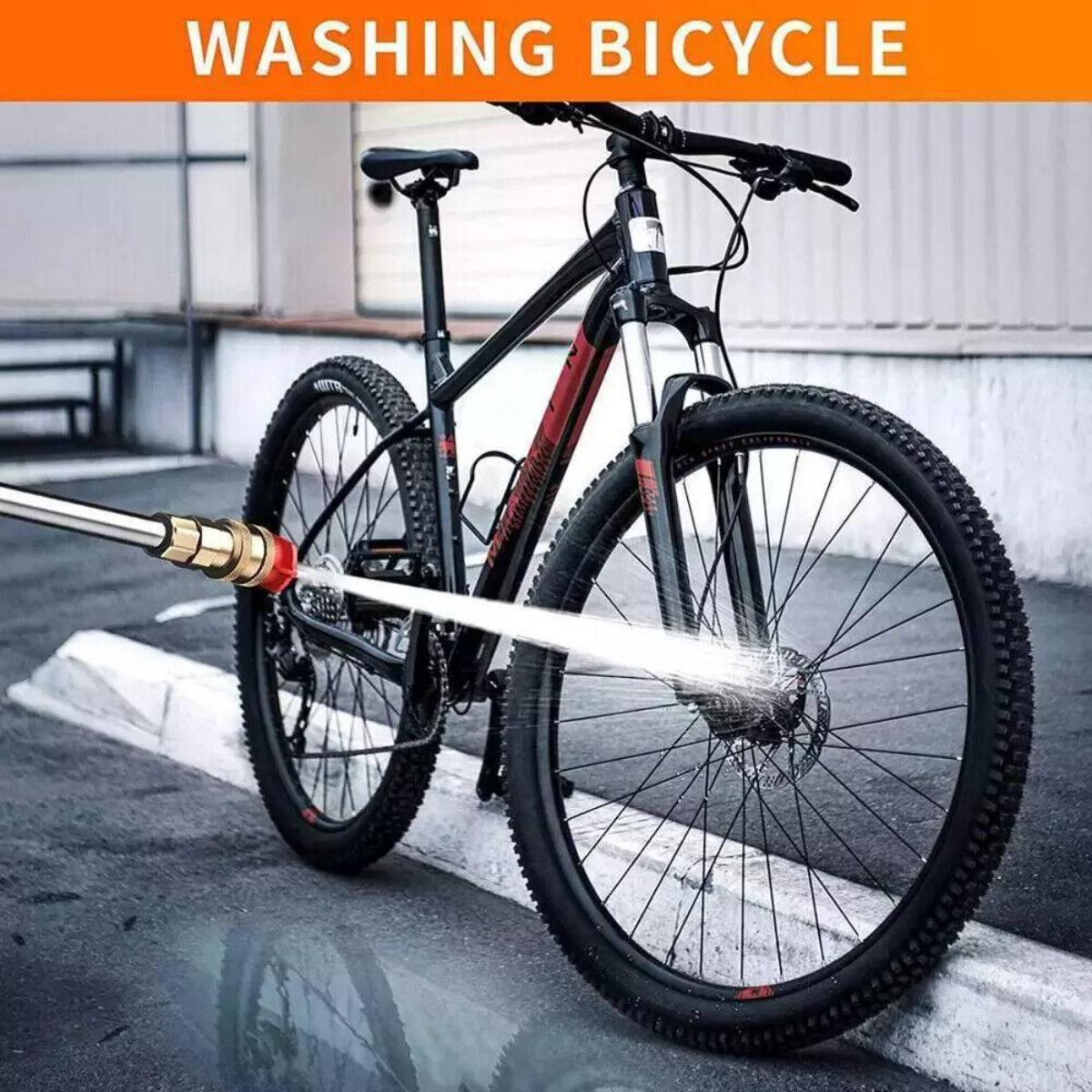 Ein schwarzes Fahrrad wird mit einem Wasserstrahl gewaschen. Das Fahrrad steht auf nassem Untergrund. Der Text oben lautet 'WASHING BICYCLE'.