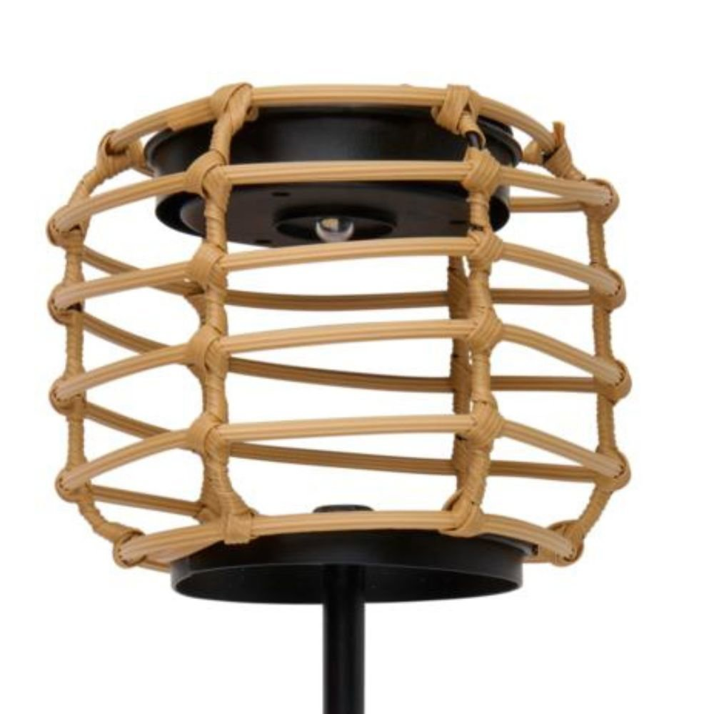 A woven rattan lamp with a black base and stem. The lamp has a cylindrical shape with a light bulb inside.