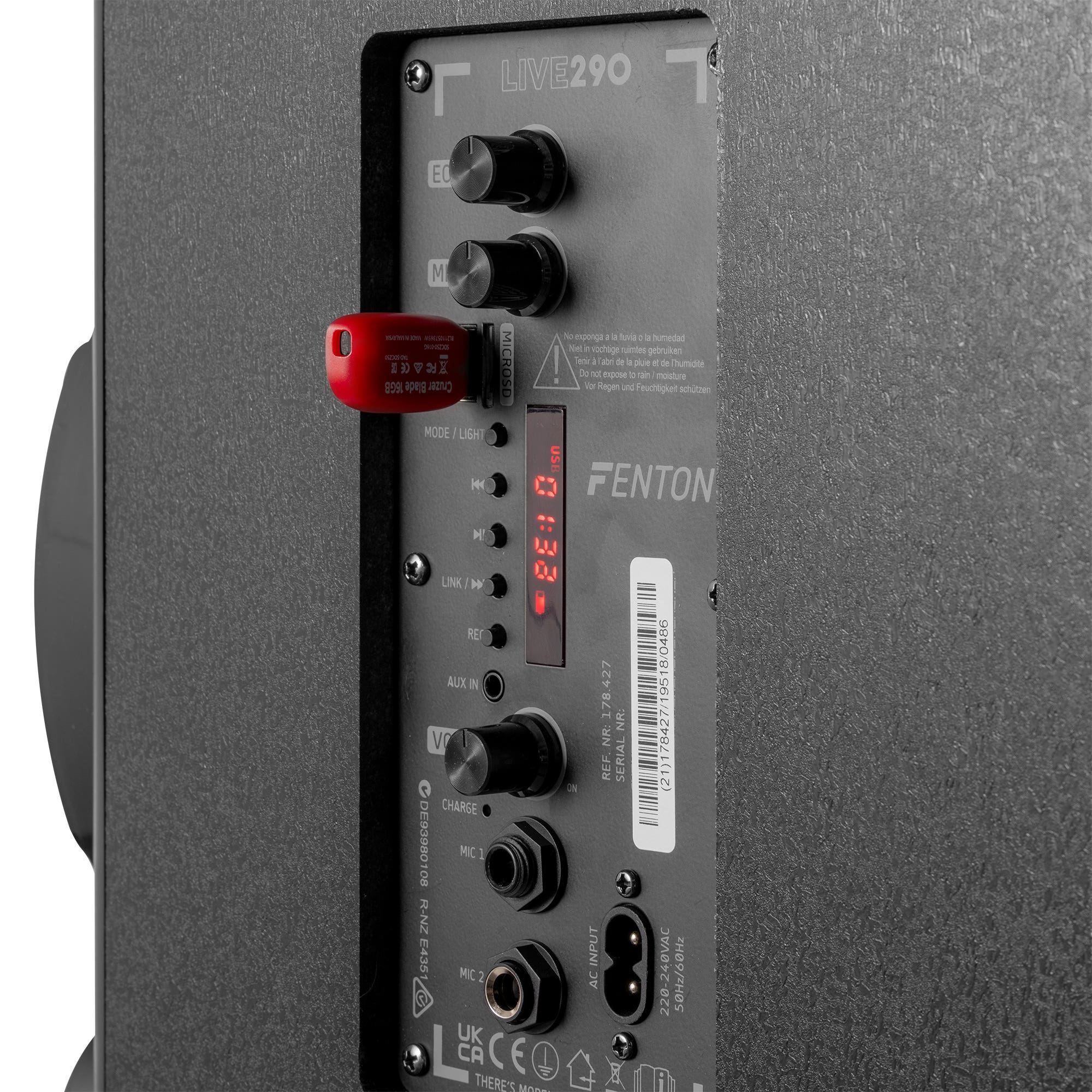 Panel negro de altavoz con perillas, entradas y una unidad USB insertada. Texto y etiquetas visibles en el panel.