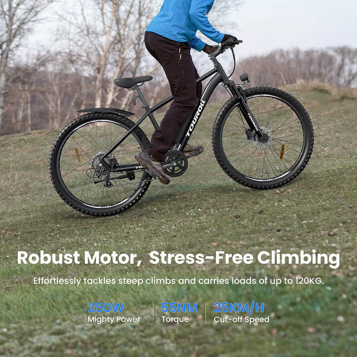 Osoba jedzie czarnym rowerem górskim pod górę. Rower jest marki Touroll. Tło przedstawia zieloną trawę i drzewa.