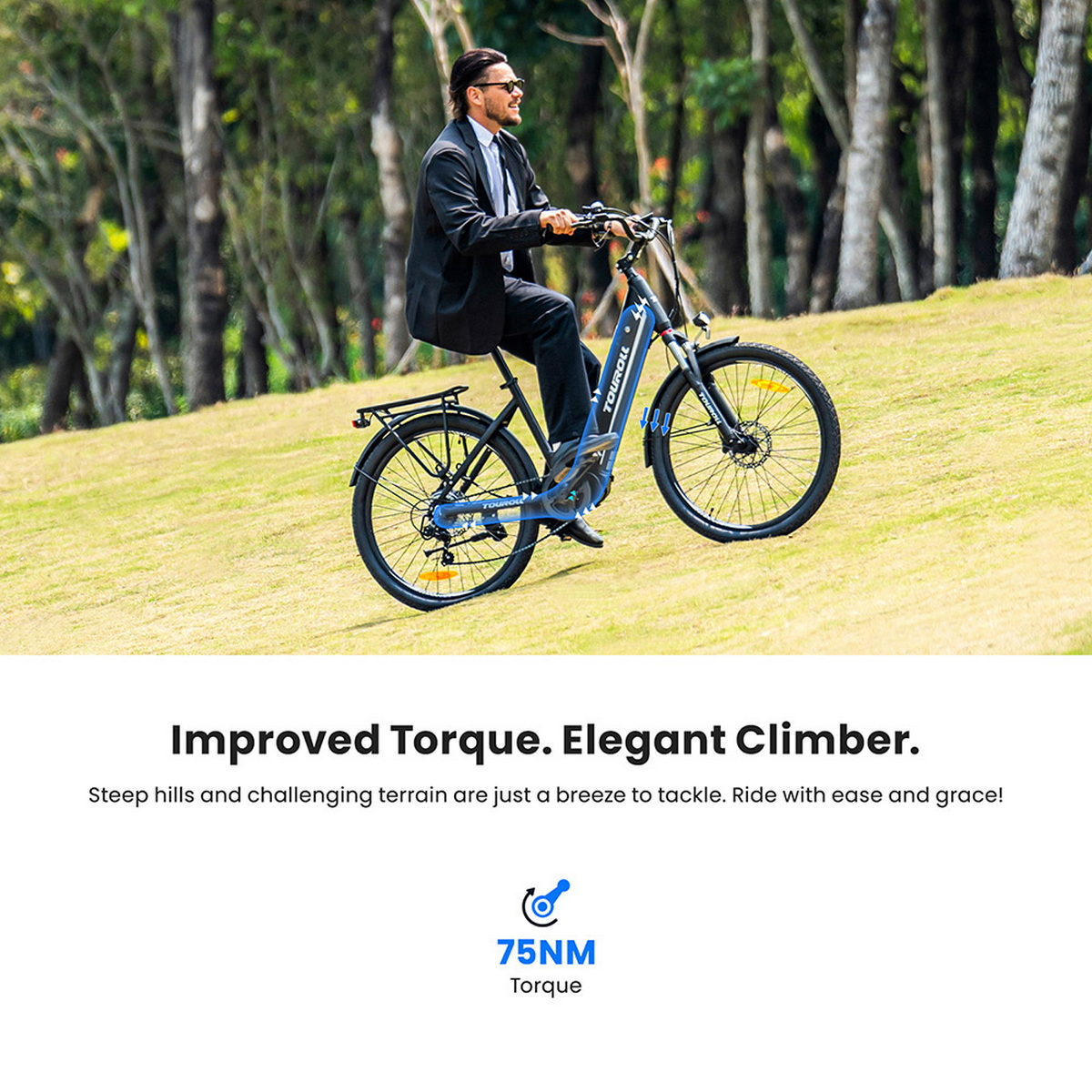 Mężczyzna w garniturze jedzie niebieskim rowerem elektrycznym pod górę po trawiastym zboczu. Drzewa w tle. Rower marki TOUROLL.