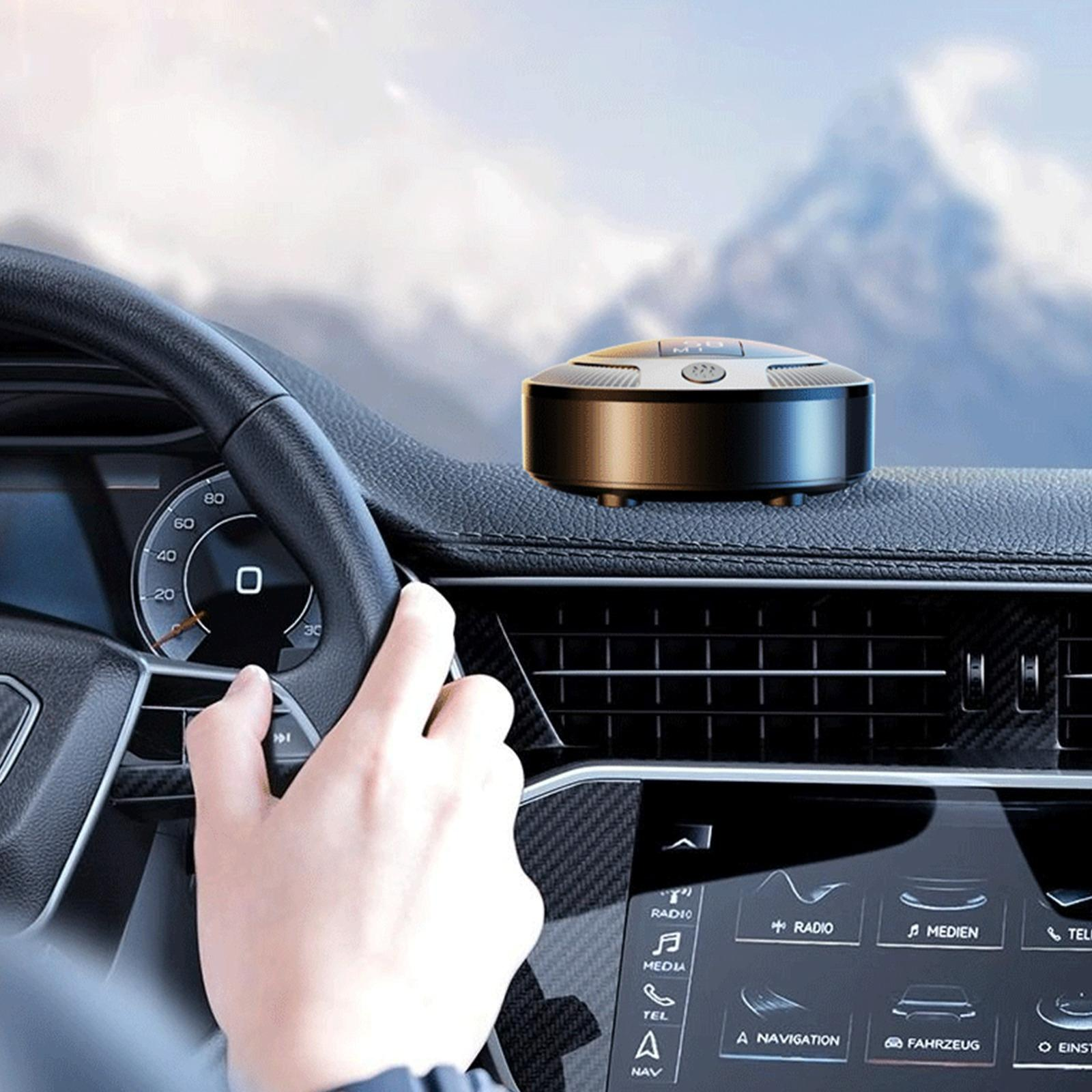 Autointerieur. Eine Hand am Lenkrad. Ein schwarzes Gerät auf dem Armaturenbrett, im Hintergrund ein Gebirge.