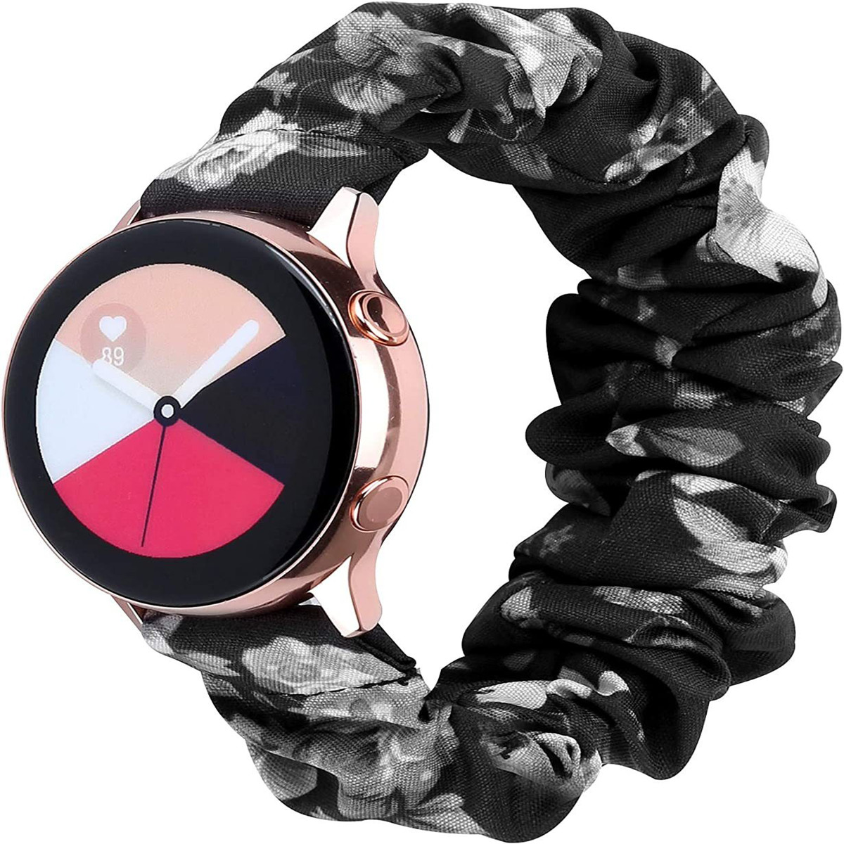 Uno smartwatch oro rosa con display nero, bianco e rosso. È attaccato a un cinturino a scrunchie con motivo floreale.
