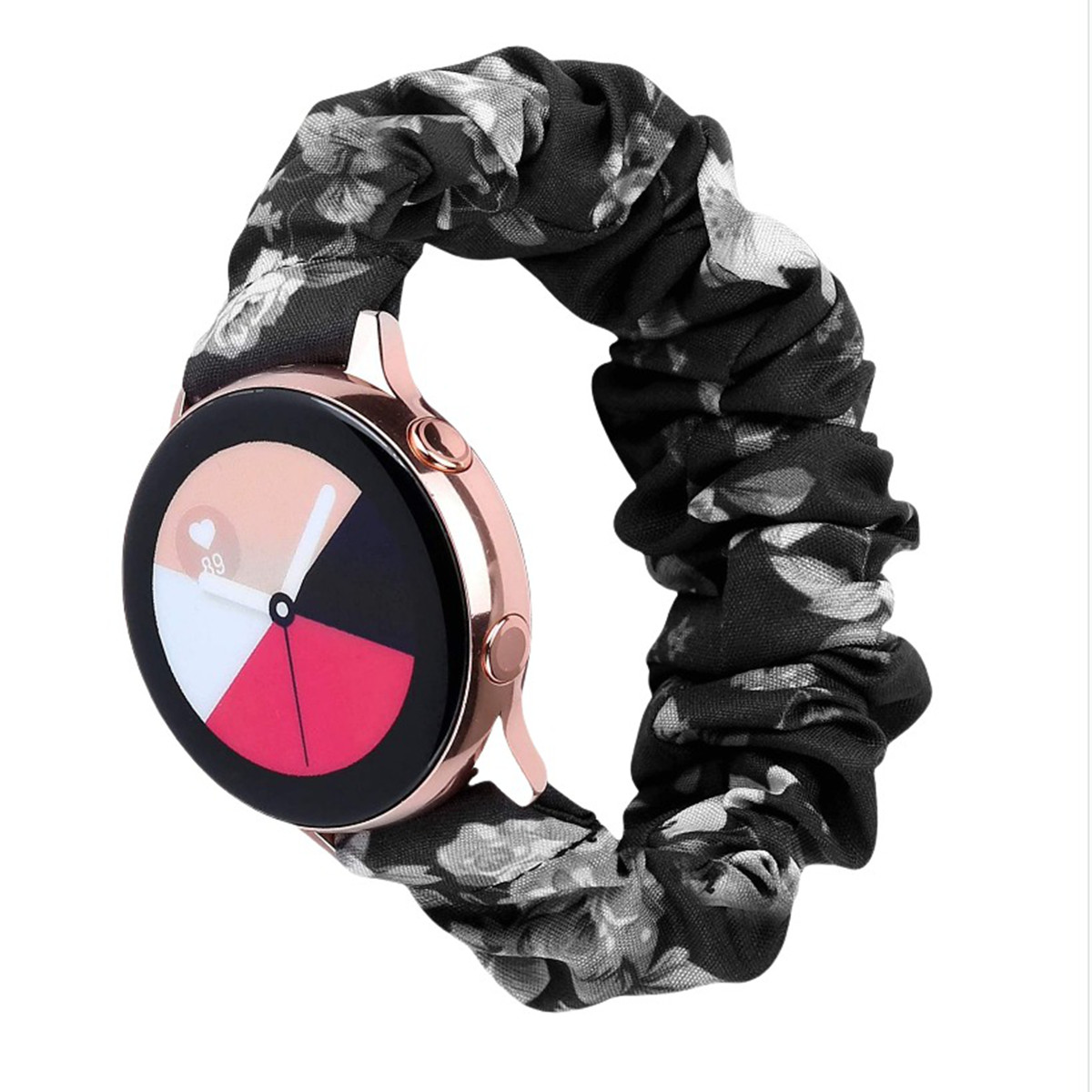 Uno smartwatch oro rosa con display nero, bianco e rosso, collegato a un cinturino scrunchie floreale nero.