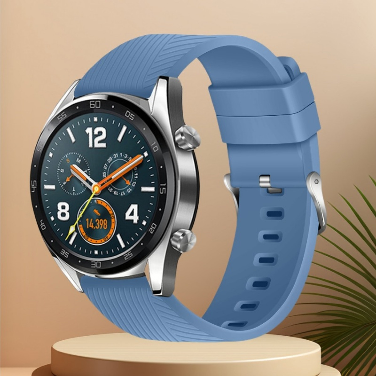 Uno smartwatch con cinturino blu è esposto su una piccola piattaforma. Il quadrante mostra numeri e lancette arancioni.