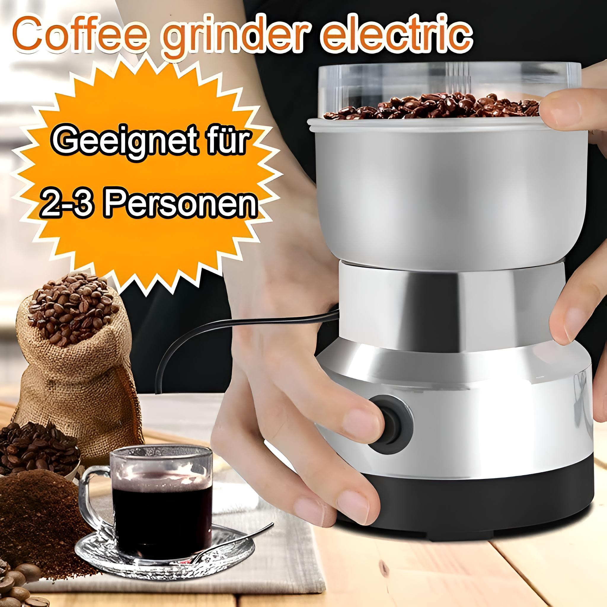 Eine elektrische Kaffeemühle mit Kaffeebohnen und einer Tasse Kaffee. Die Mühle ist silberfarben, und eine Hand drückt einen Knopf.