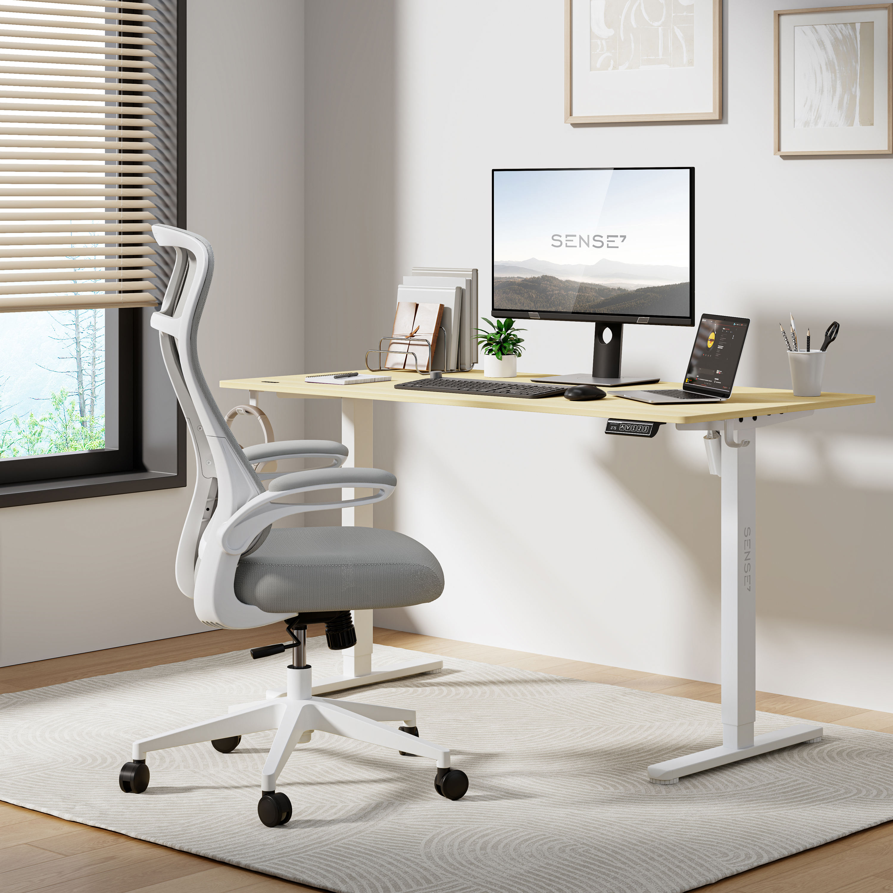 Kantooropstelling: witte stoel, verstelbaar bureau met monitor, laptop en accessoires. Natuurlijk licht.