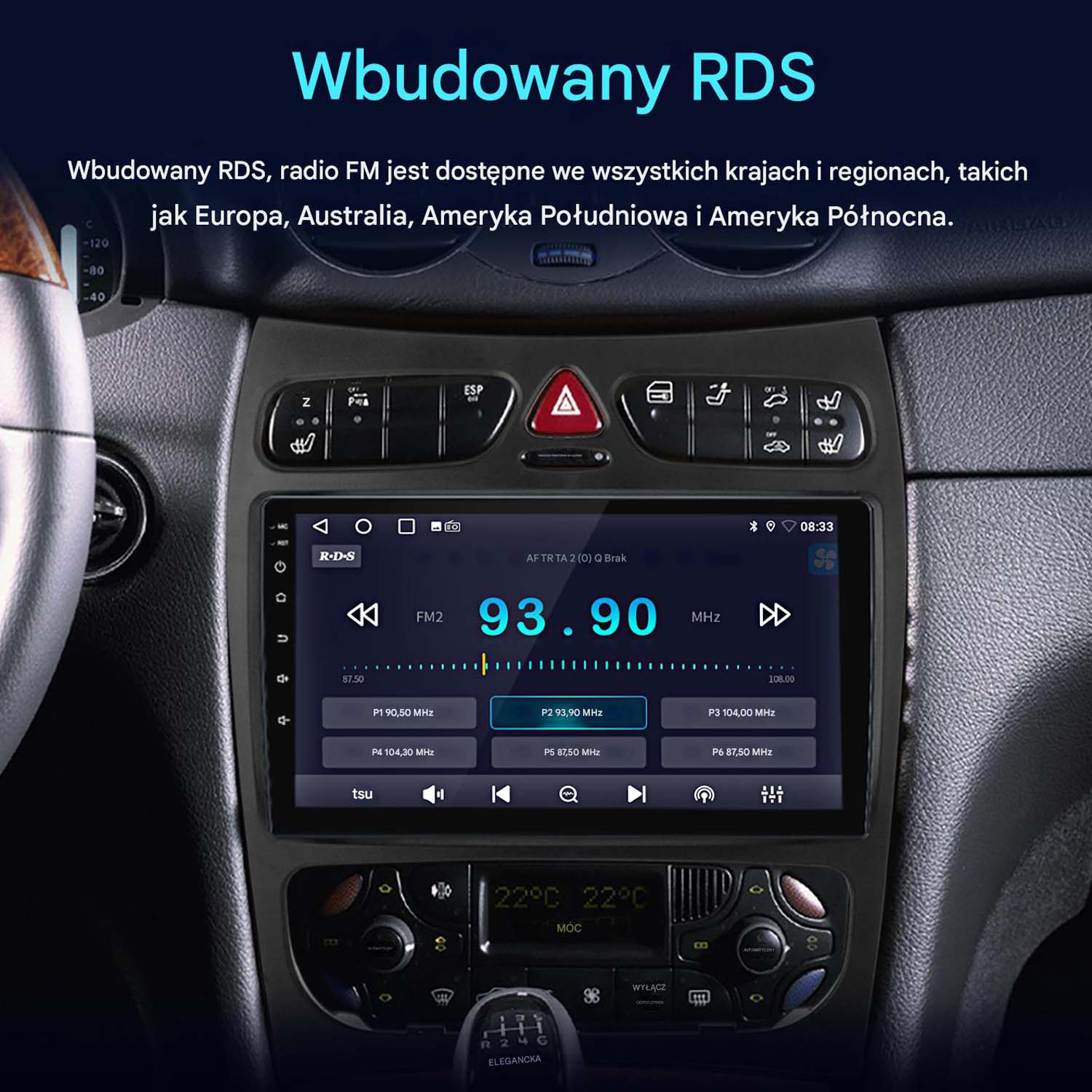 Ekran radia samochodowego wyświetlający częstotliwość radia FM. Przyciski i pokrętła otaczają ekran. Widoczna deska rozdzielcza i kierownica.