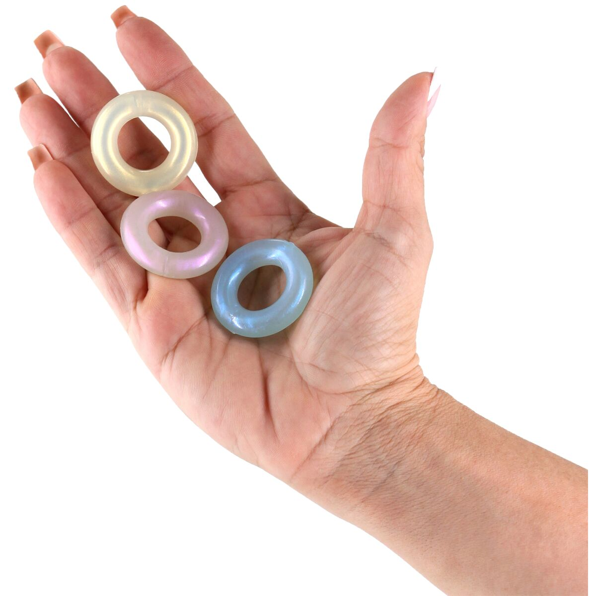Eine Hand hält drei irisierende, donut-förmige Objekte. Die Objekte sind gelb, rosa und blau. Der Hintergrund ist weiß.