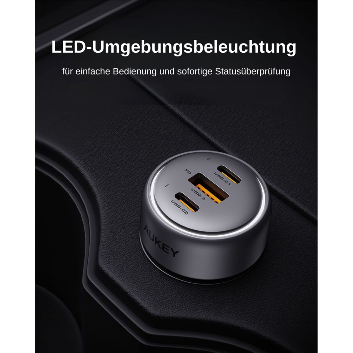 Un cargador de coche AUKEY plateado con tres puertos USB y una luz LED, colocado en la consola del coche.