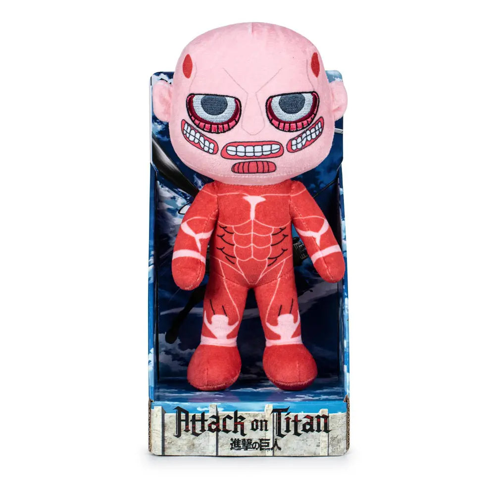 Ein Plüschtier eines Titans aus Attack on Titan. Das Spielzeug befindet sich in einer Box mit dem Attack on Titan-Logo. Es ist rot und rosa.