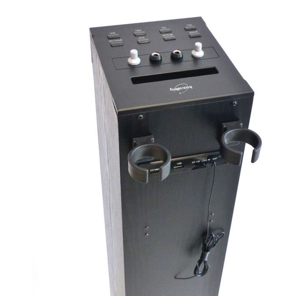 Altoparlante nero con pulsanti, manopole e portabicchieri. Include porte USB e SD. Cavo di alimentazione che pende. Sfondo bianco.
