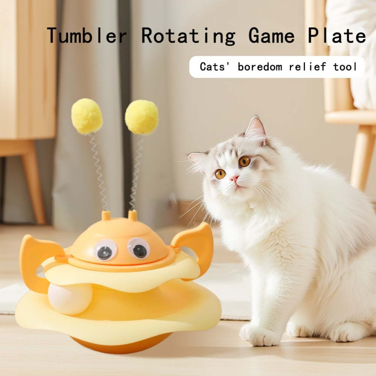 Eine weiße Katze betrachtet ein orangefarbenes Katzenspielzeug mit gelben Bällen. Der Text lautet 'Tumbler Rotating Game Plate' und 'Cats' boredom relief tool'.