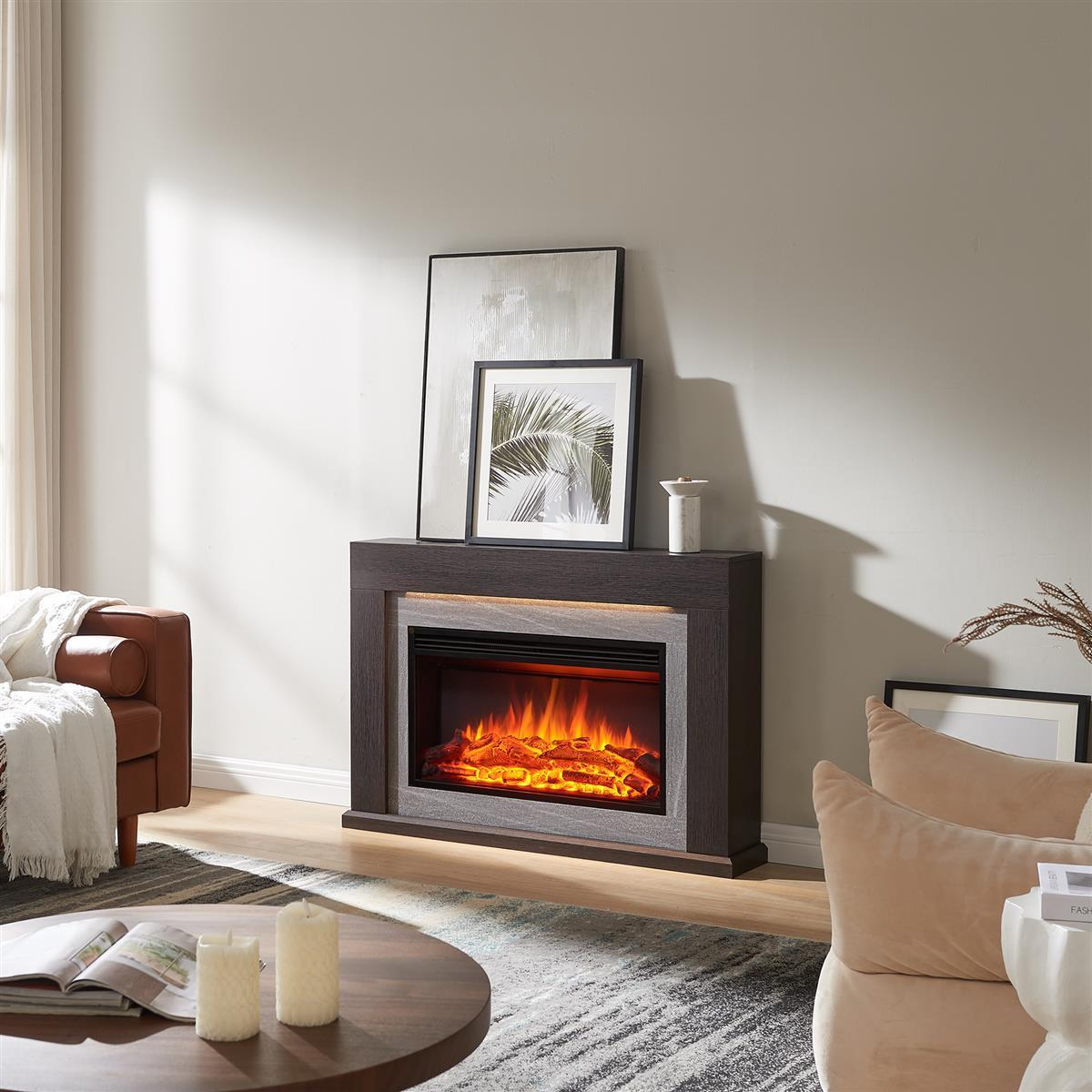 Ein Kamin mit künstlichen Flammen steht unter gerahmten Kunstwerken. Eine braune Ledercouch und ein runder Couchtisch sind im Vordergrund.